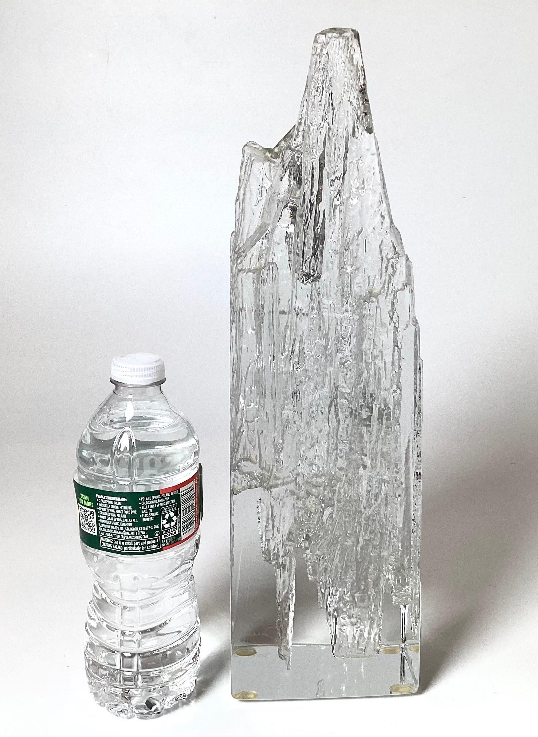 A clear art glass sculpture in a Brutalist style of an iceberg by Daum made in France, signed at the bottom, 1970s. Measures: 14.5 inches tall, 4.25 wide, 3.5 deep.