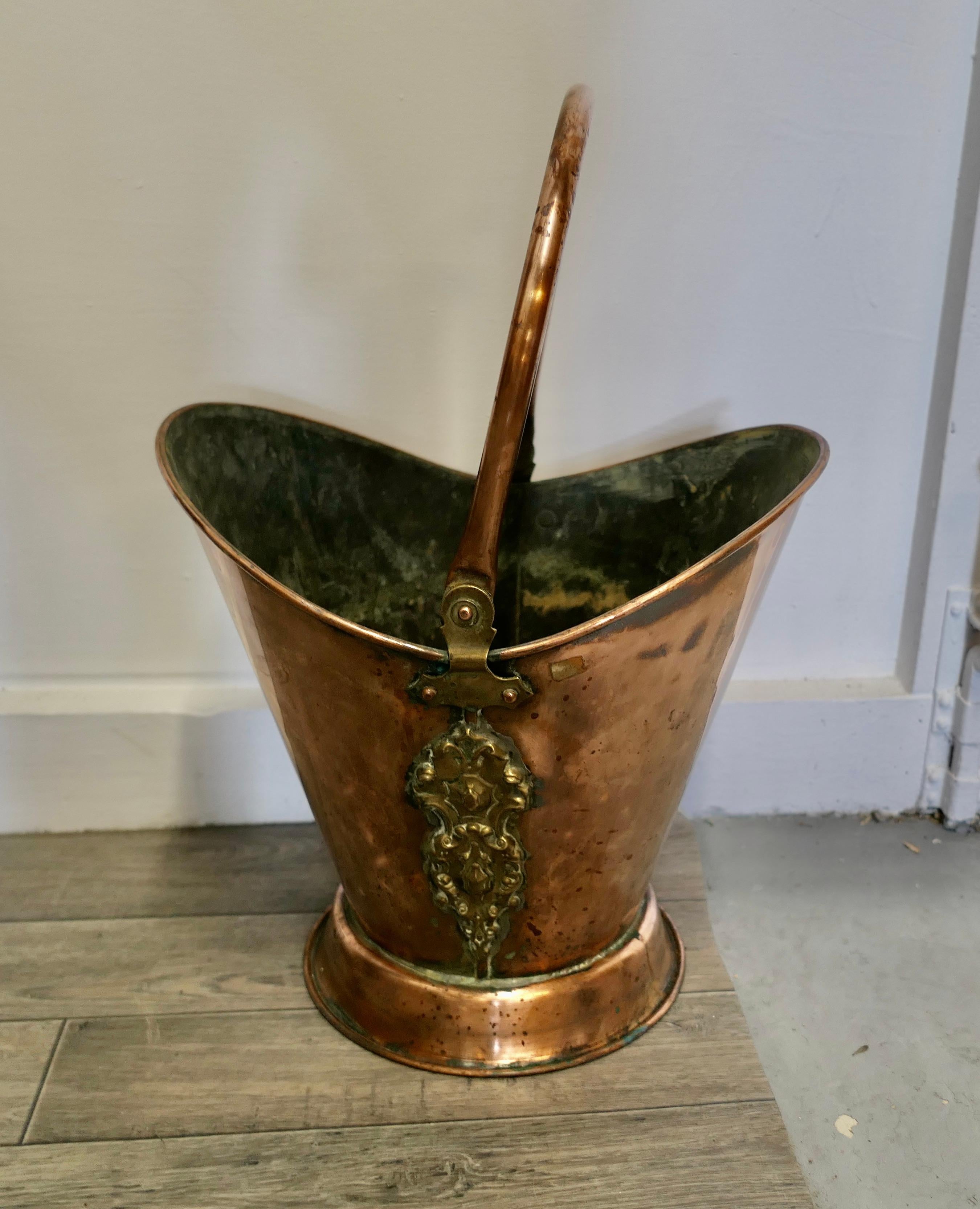 An Art Nouveau Embossed copper helmet coal scuttle 

This bucket is a very attractive Oval shape, it is made in beaten Copper with a swing handle 
The Scuttle is in very good used condition, and is ready to go to work and grace your fireside at