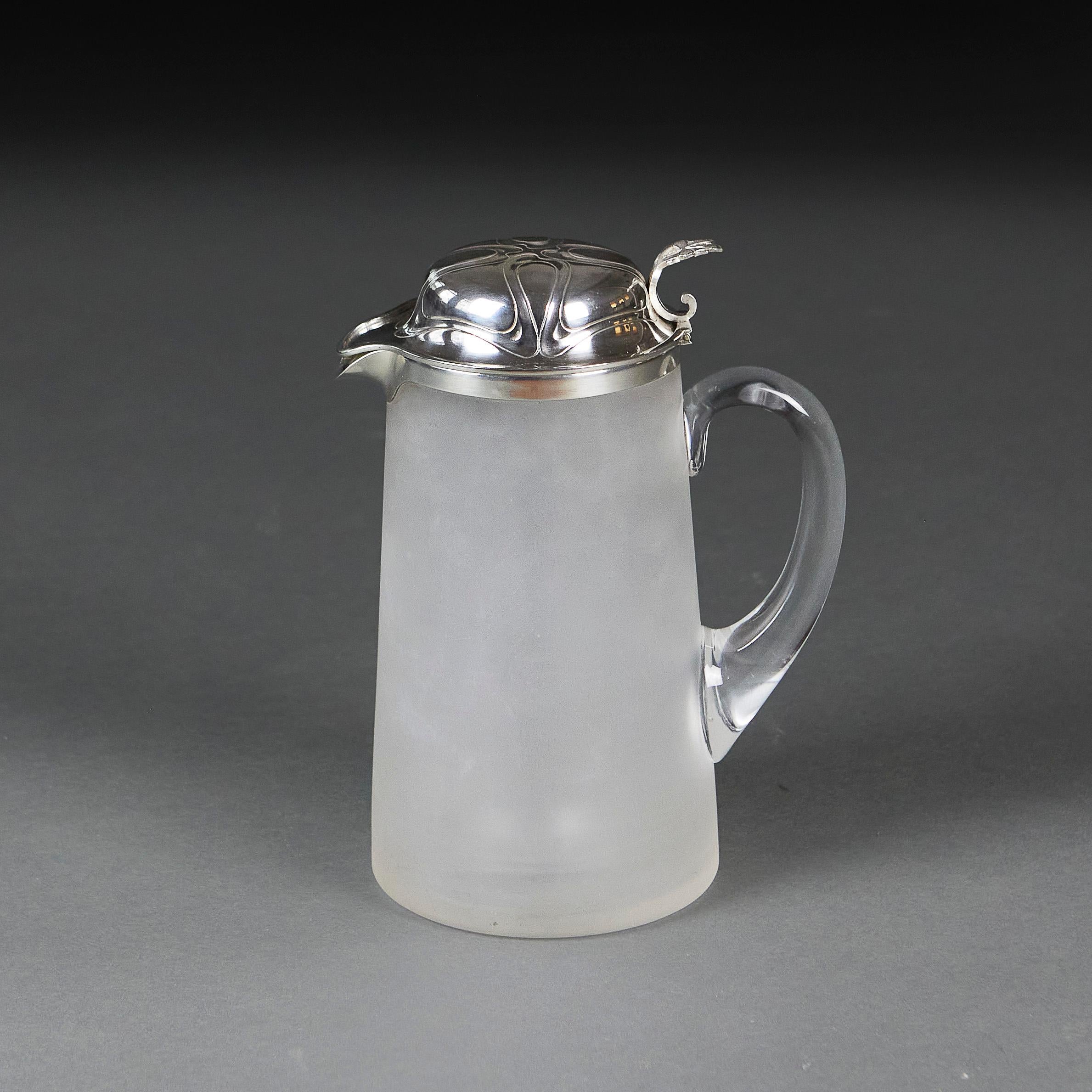 France, circa 1910
An Art Nouveau frosted glass lemonade jug, with engraved silver lid of foliate designs and glass ice pocket cavity within. 

Height    26.00cm
Diameter    13.00cm