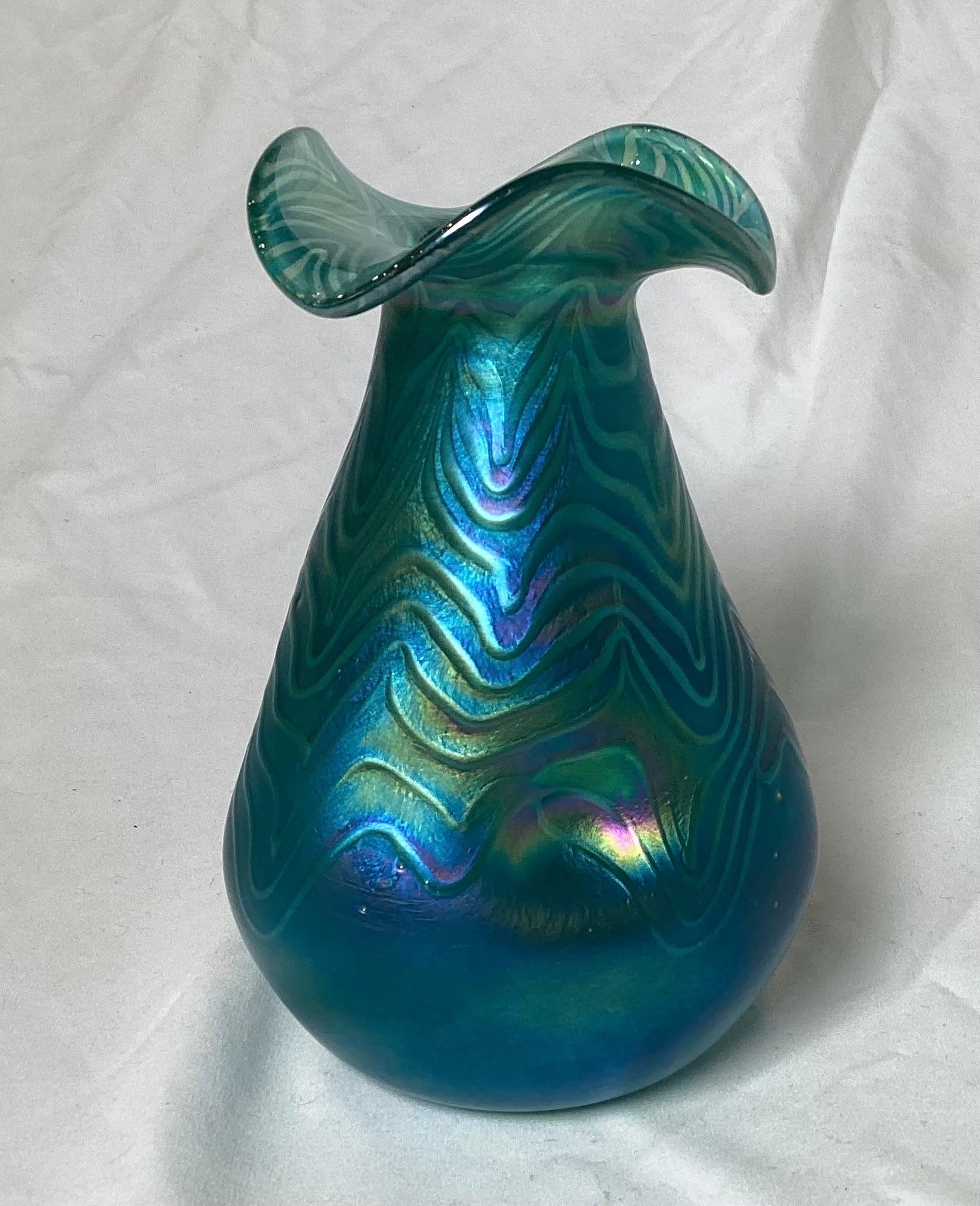 A blue oil slick finished hand blown glass vase in the manner of Loetz. The ruffled top with dimpled sides, 6 inches tall.