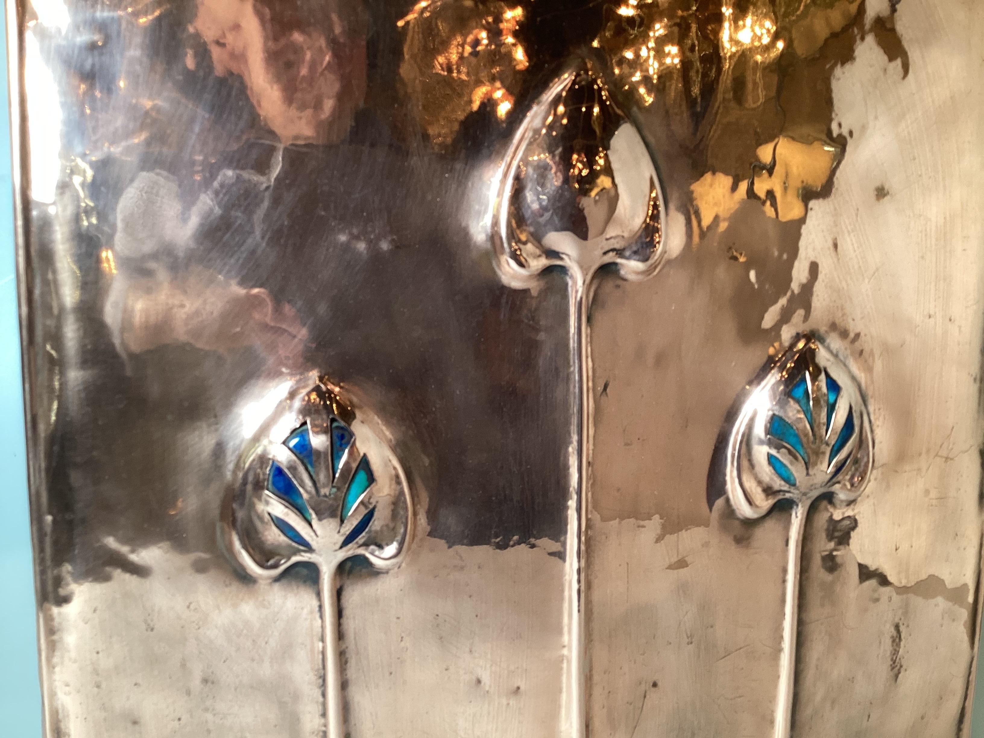 A beautiful polished copper fire screen from the Art Nouveau period with class styling from the time period, The screen with stylish flower heads with colored art glass inserts.  The base is wrought iron feet. 26 inches high, 19.5 inches wide.