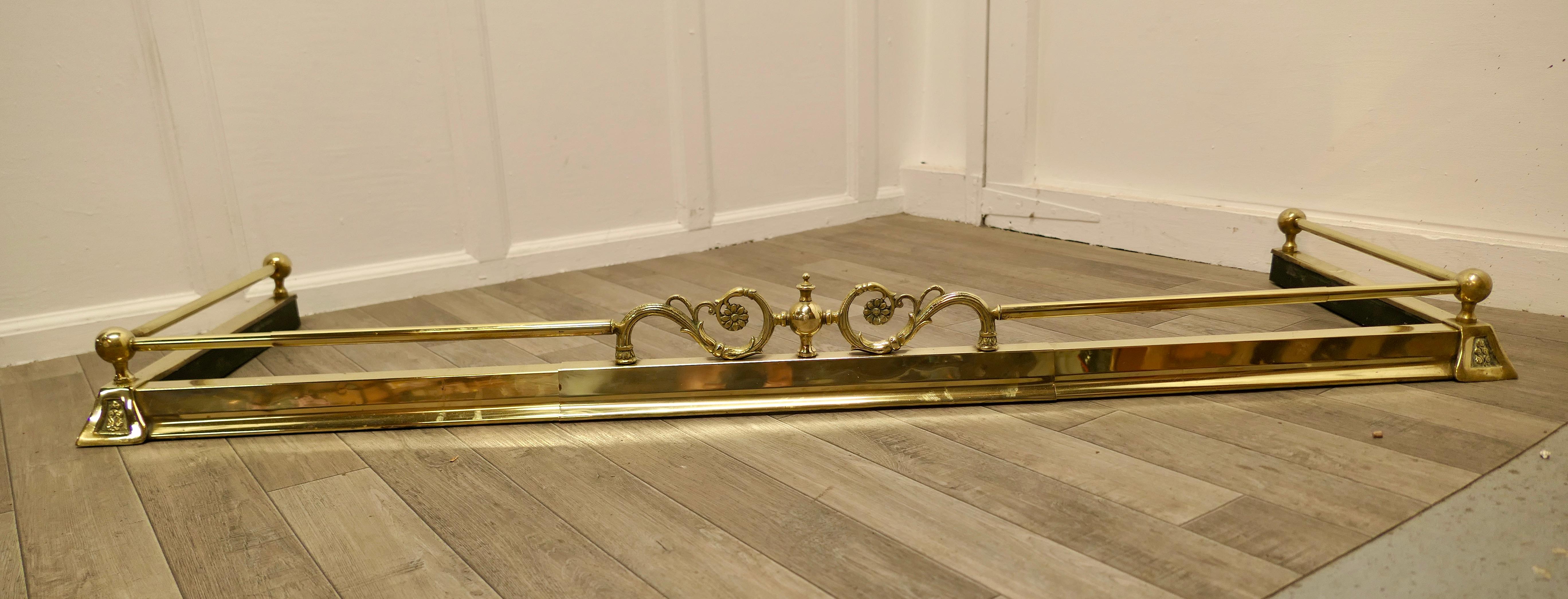 An Art Nouveau Victorian extending brass fender 

This is a very attractive Brass Fender it has a decorative centre section in the Art Nouveau style with swirls and flowers in the brass rail above the simple brass base
The Fender is in good