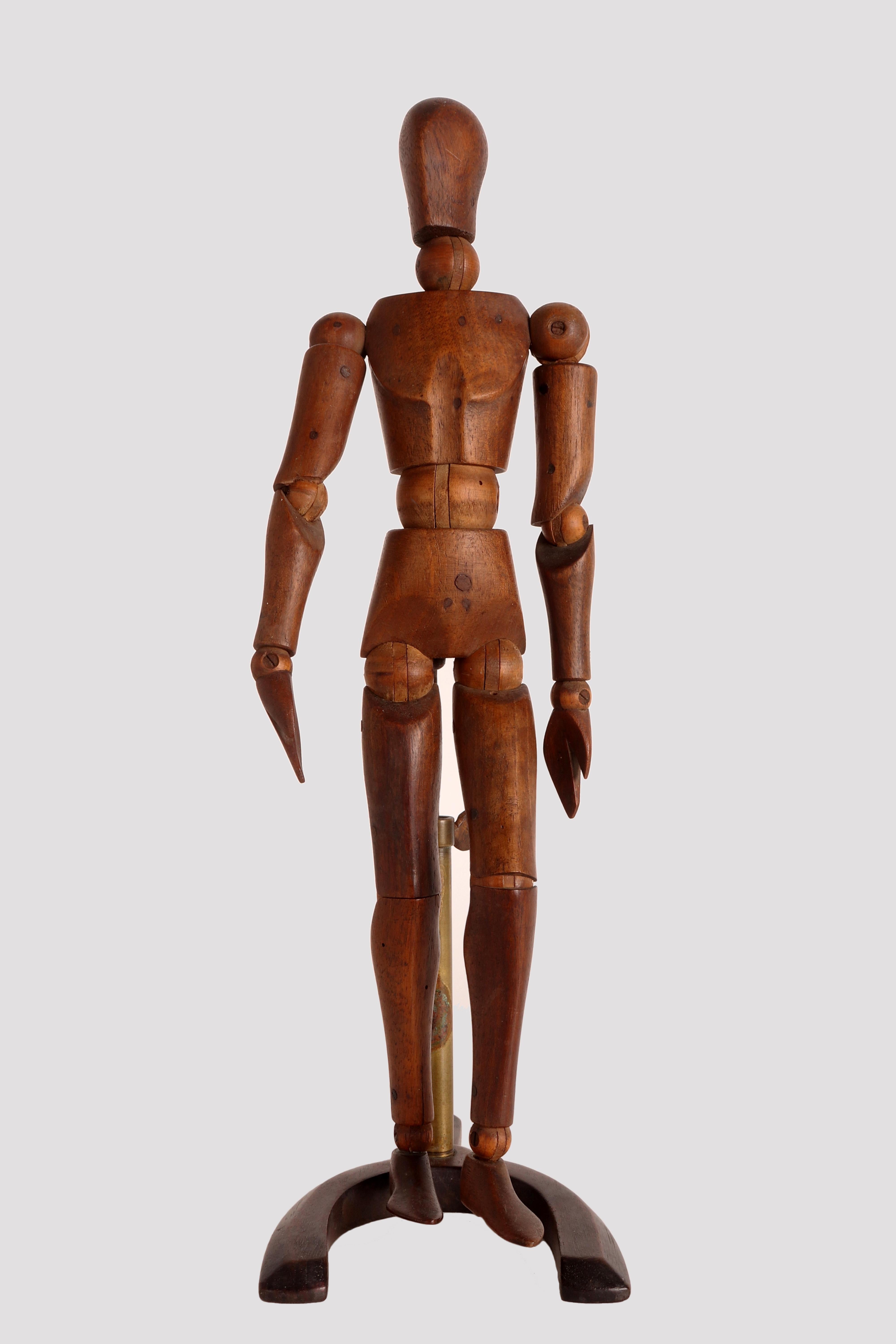 An articulated mannequin of a small-sized painter, with a metaphysical face. 
The mannequin is made of carved fruit wood. The support is in brass and the base, 
also made in fruit wood, U shape. France, circa 1920.
   