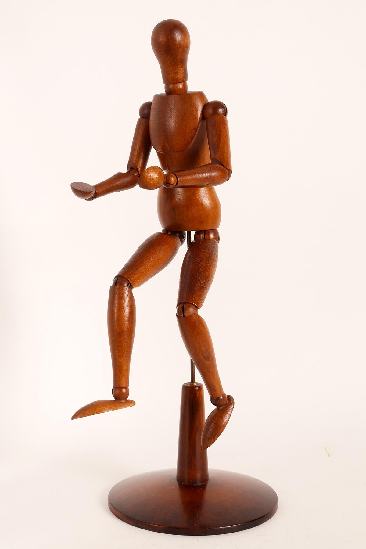An articulated mannequin of a small-sized painter, with a metaphysical face. 
The mannequin is made of carved oak wood. The support is in brass and the base, 
made out of fruit wood, round shape. France, circa 1920.
 