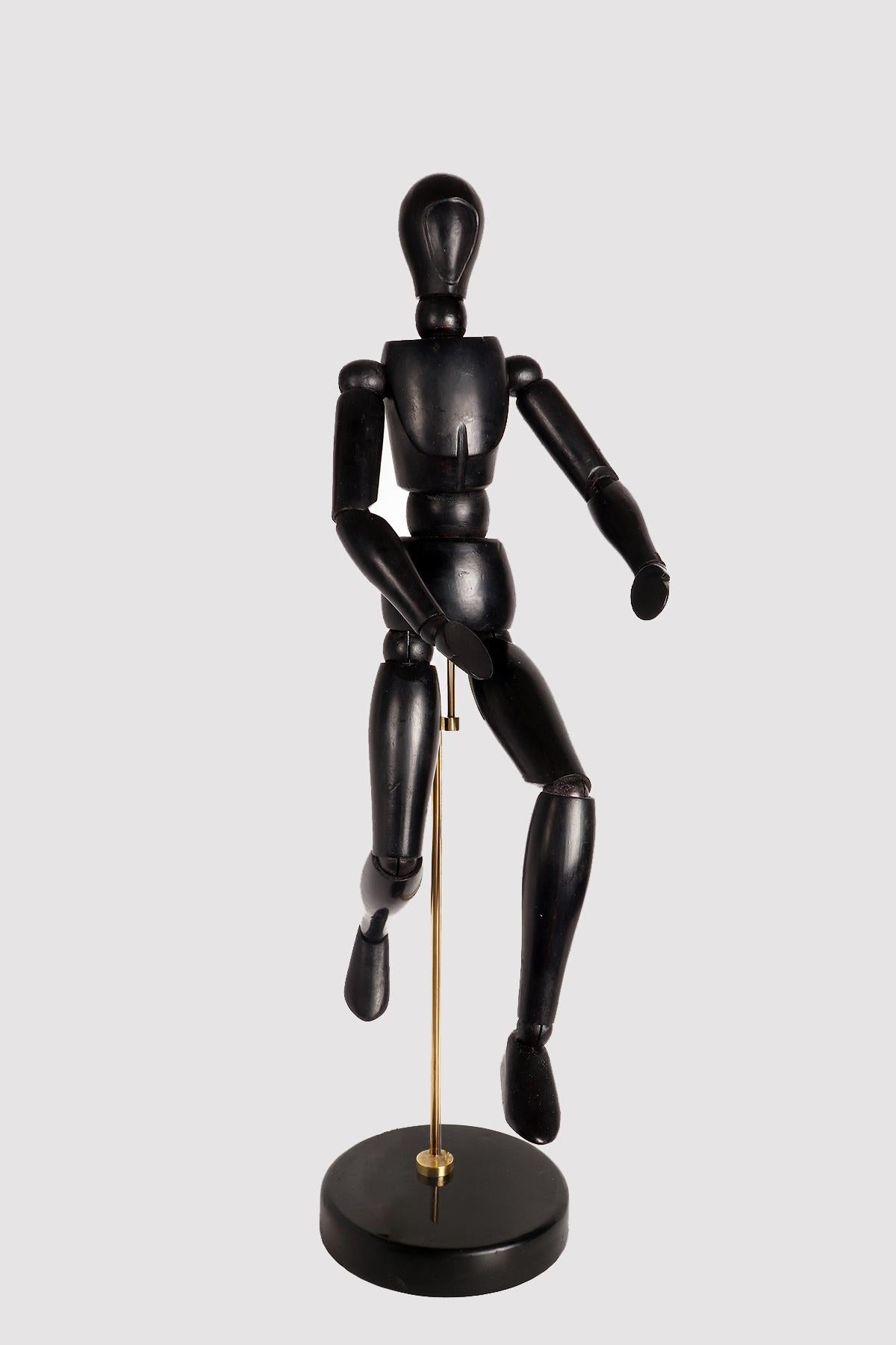 An articulated painter's mannequin of medium size, with a metaphysical face. The mannequin is made of carved and ebonized oak wood. The support is in brass and the base, also made in a round shape in ebonized oak wood. France, circa 1920.
(The