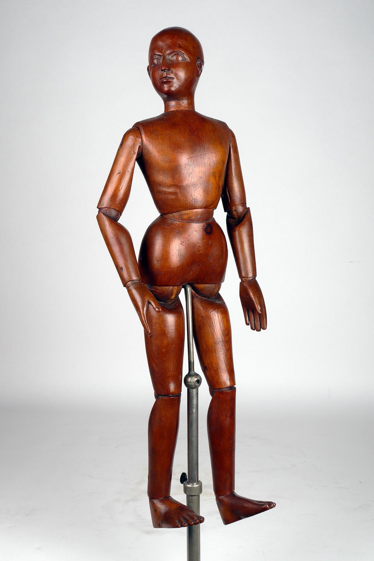 An articulated mannequin of a medium-sized painter, with the face to life. The mannequin is sculpted and made of fruit wood. The height-adjustable stand (40” – 55”, diameter 8”), is in white metal. Italy, around 1880