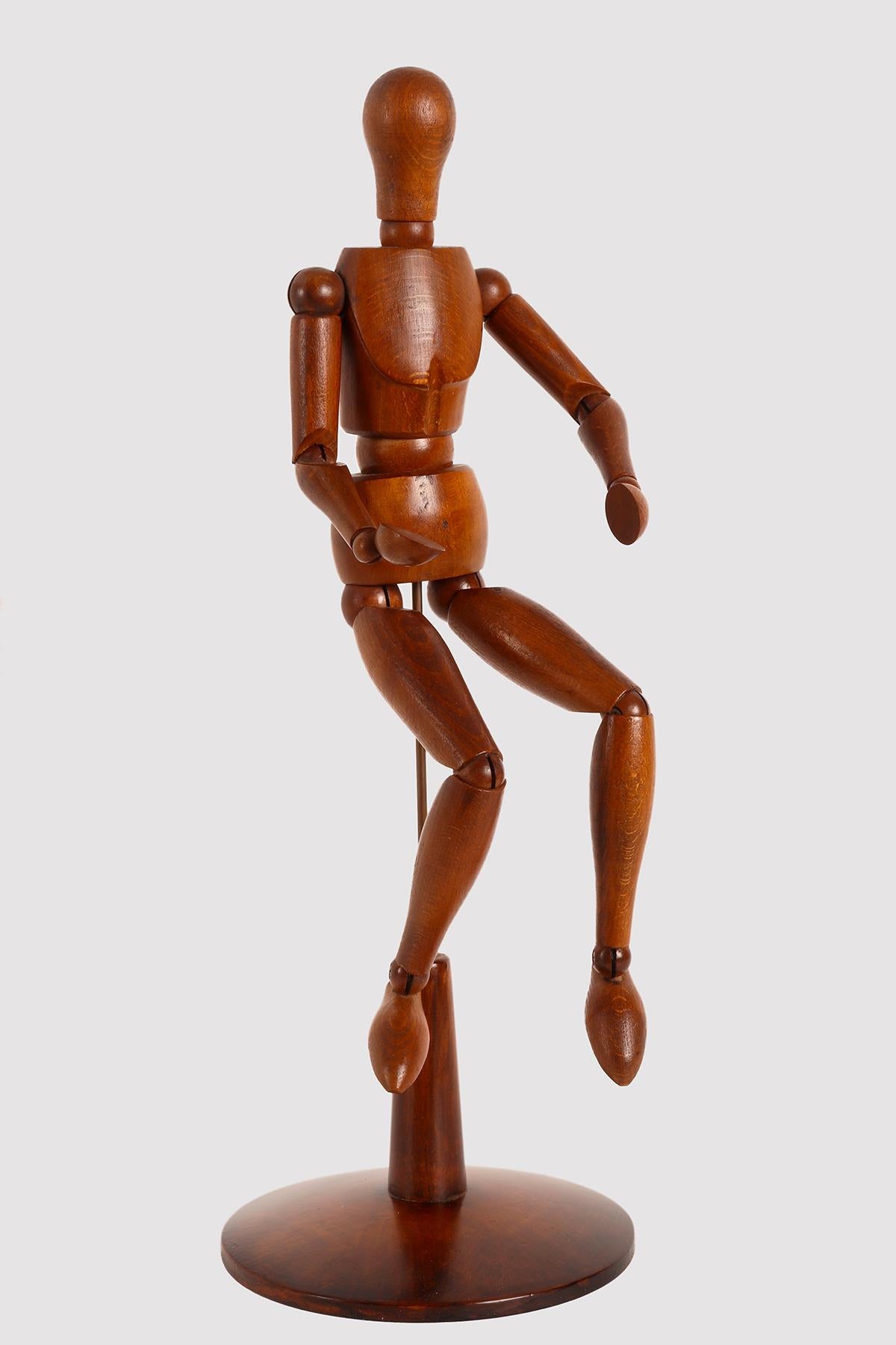 An articulated mannequin of a small-sized painter, with a metaphysical face. 
The mannequin is made of carved oak wood. The support is in brass and the base, 
made out of fruit wood, round shape. France, circa 1920.