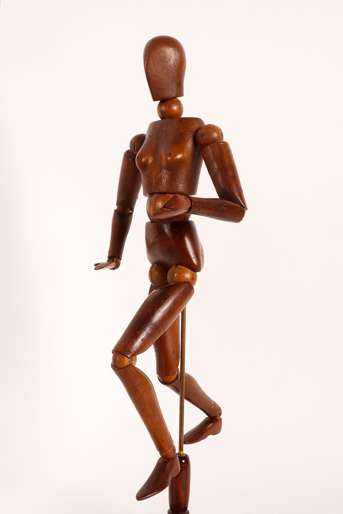 Painter's articulated mannequin depicting a woman, with a metaphysical face. The mannequin is made of carved national walnut wood for the body parts and maple wood for the spheres in the joints. The base is made out of fruitwood with a brass