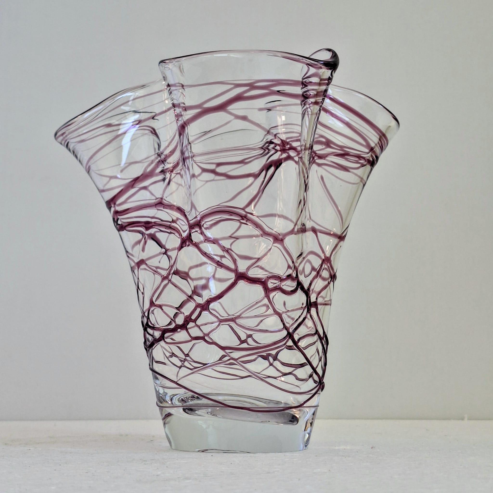 Un vaso decorativo in vetro dall'aspetto artistico e soffiato a mano. Ha una base e un corpo trasparenti, con linee di vetro viola o viola irregolari e fluide, fuse all'interno del vetro trasparente.

Il vaso ha una forma organica e asimmetrica: il