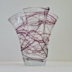 An artistic vase with irregular violet glass lines