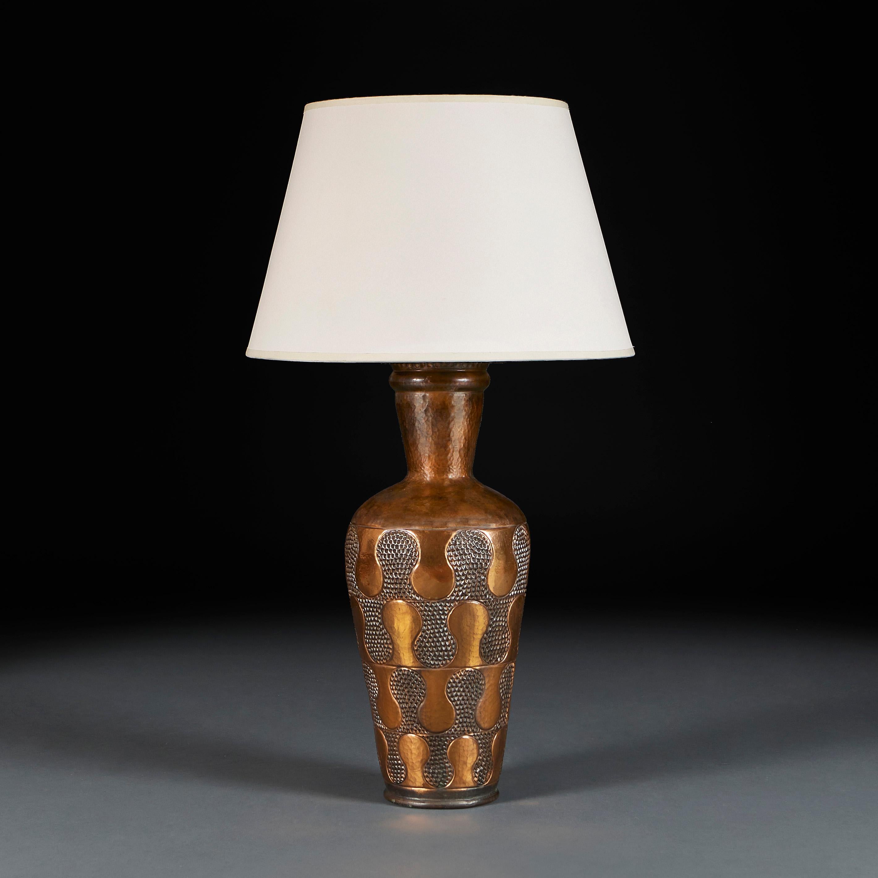 England, circa 1920

An early twentieth century arts and crafts hammered copper vase of tapering form with punched wave design and frilled rim, now converted as a lamp.

Height of vase 52.00cm
Height with shade 81.00cm
Diameter of base