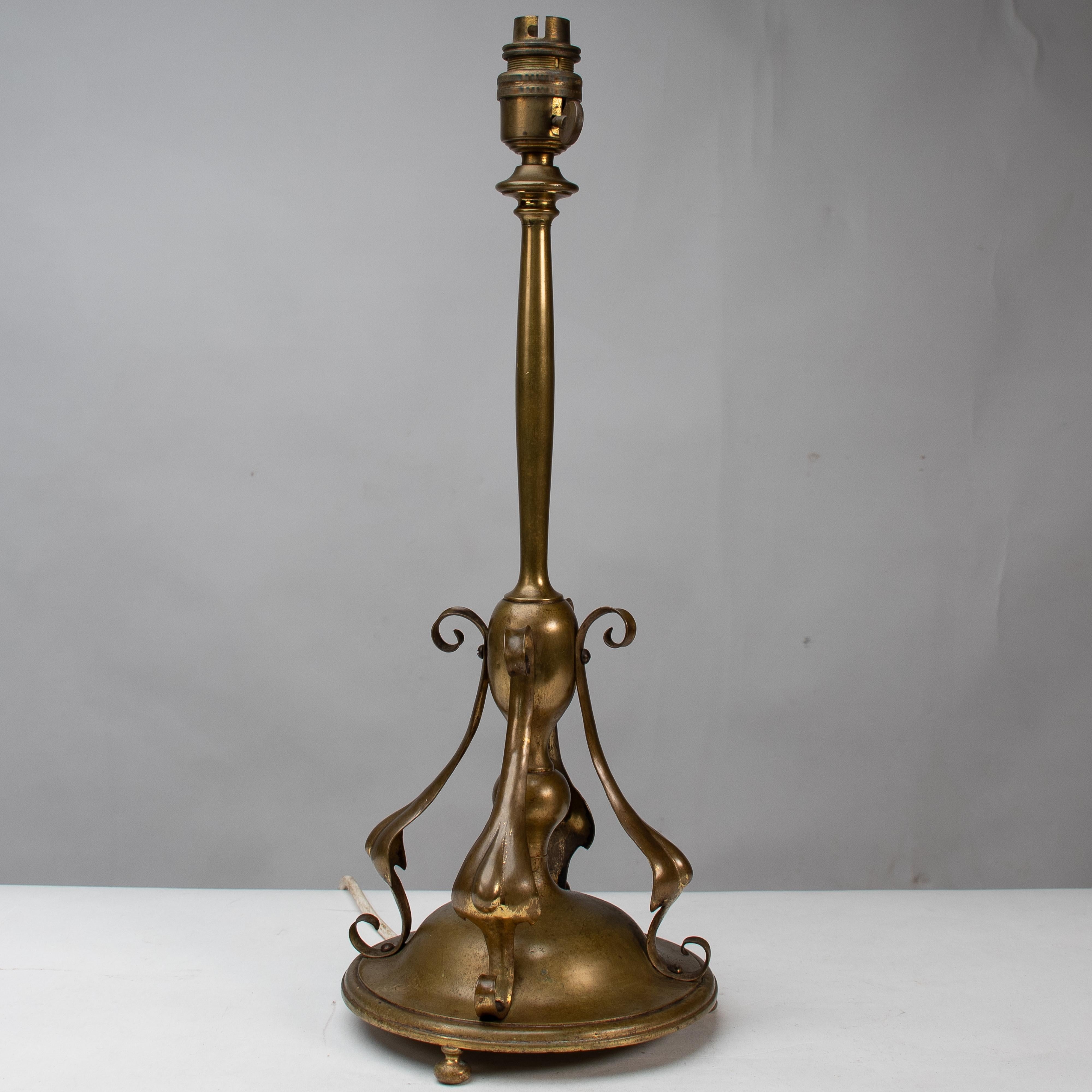 An Arts and Crafts brass table lamp in the style of C F A Voysey.