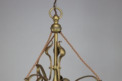 An Arts and Crafts brass three arm ceiling light