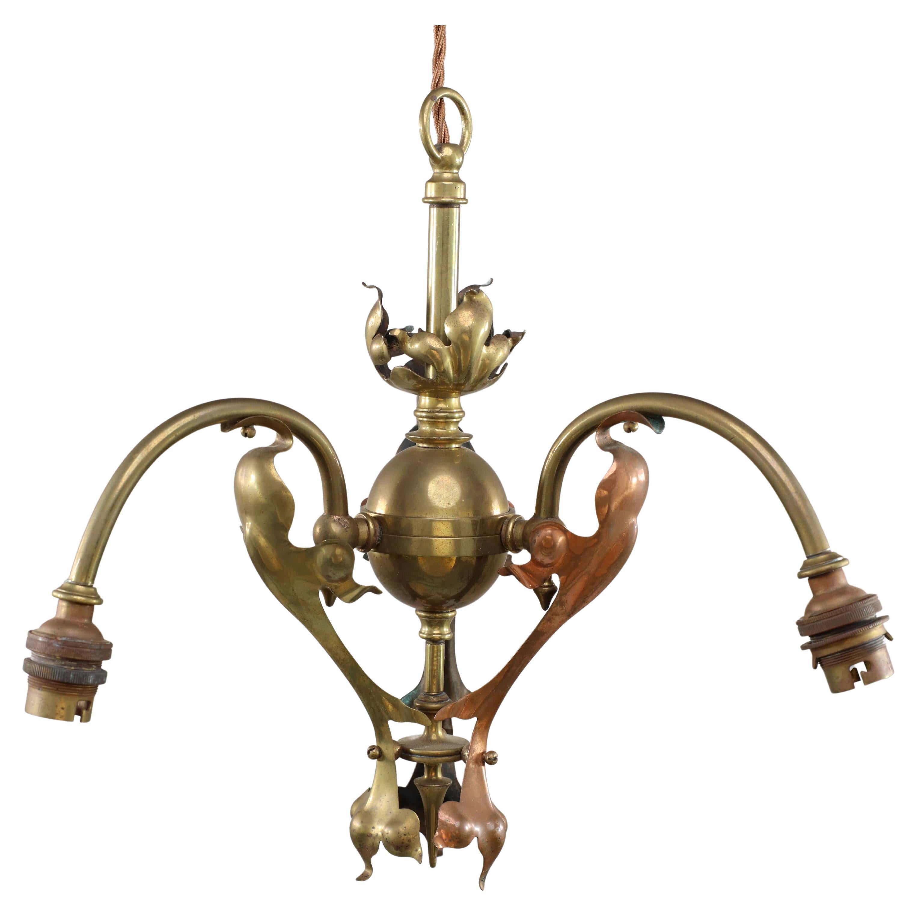 An Arts and Crafts brass three arm ceiling light with a flower bud to the top For Sale