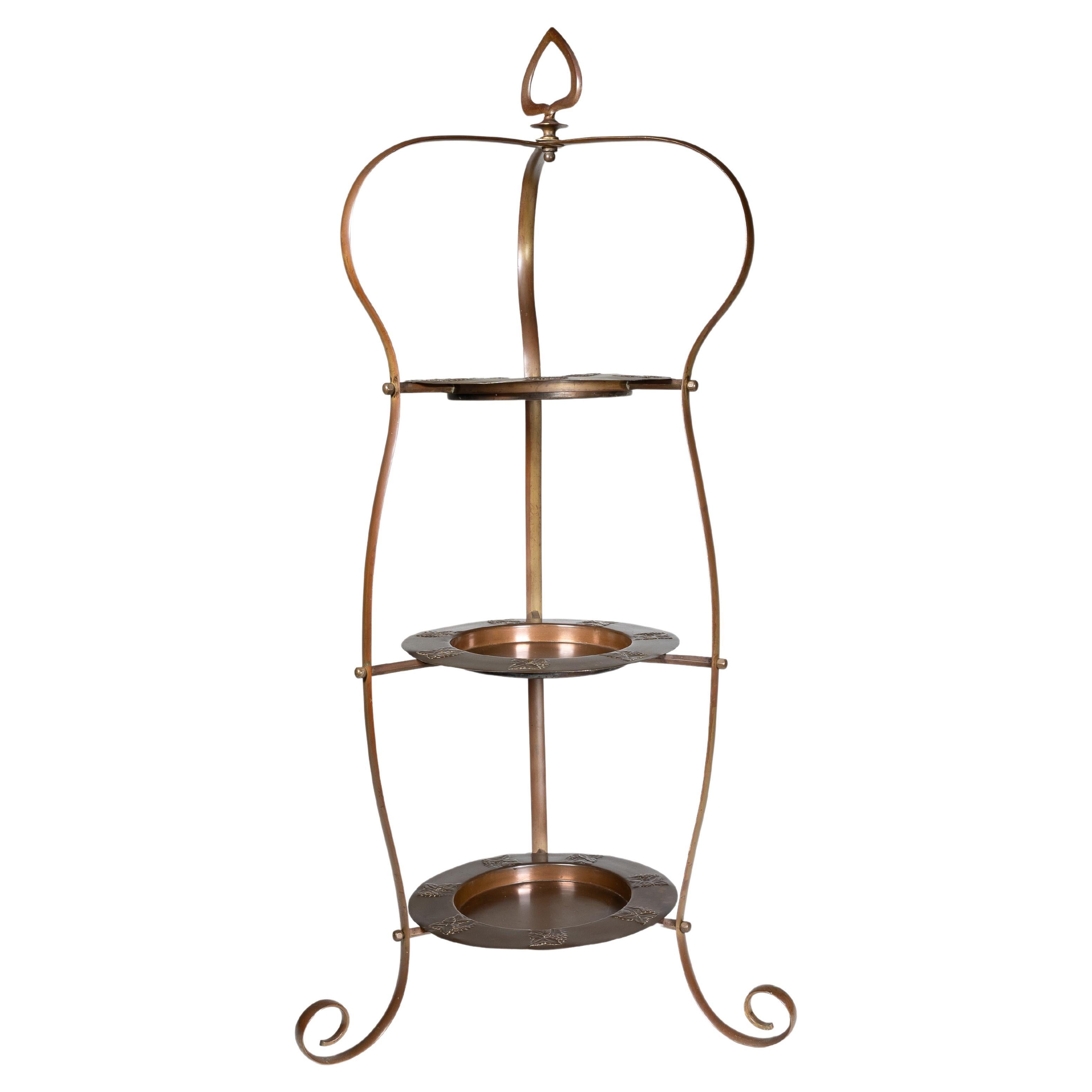 Un soporte para tartas de cobre Arts and Crafts con tres platos de cobre a juego