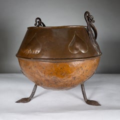 An Arts and Crafts copper coal bucket with stylized heart decoration