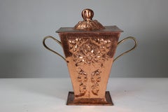 An Arts & Crafts copper coal bucket & lid with all over sunflower decoration.
