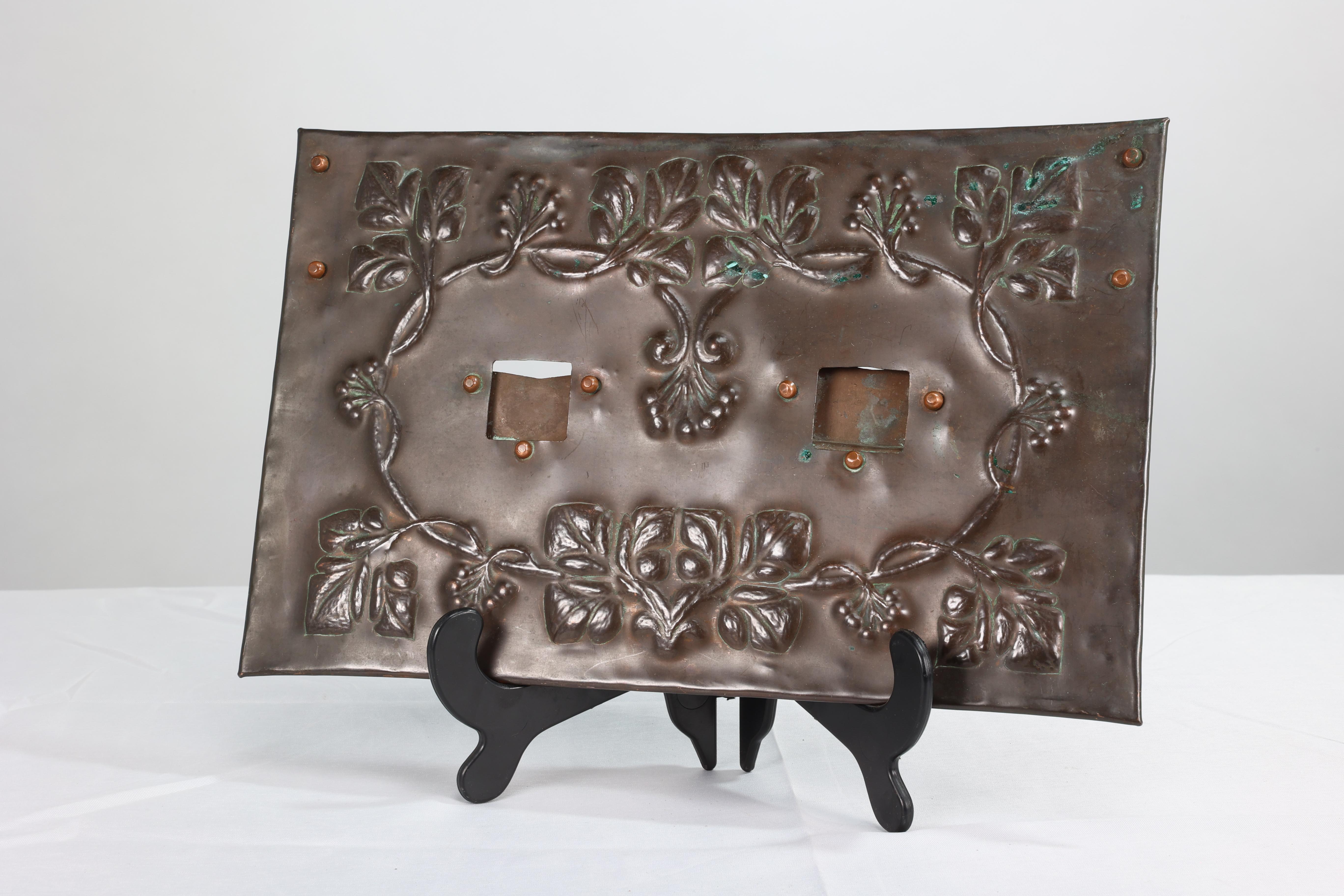 Ein kupferner Hängerahmen im Arts-and-Crafts-Stil mit handgeformtem Blumendekor aus Blättern und Beeren und kleinen quadratischen Öffnungen für zwei Fotos.