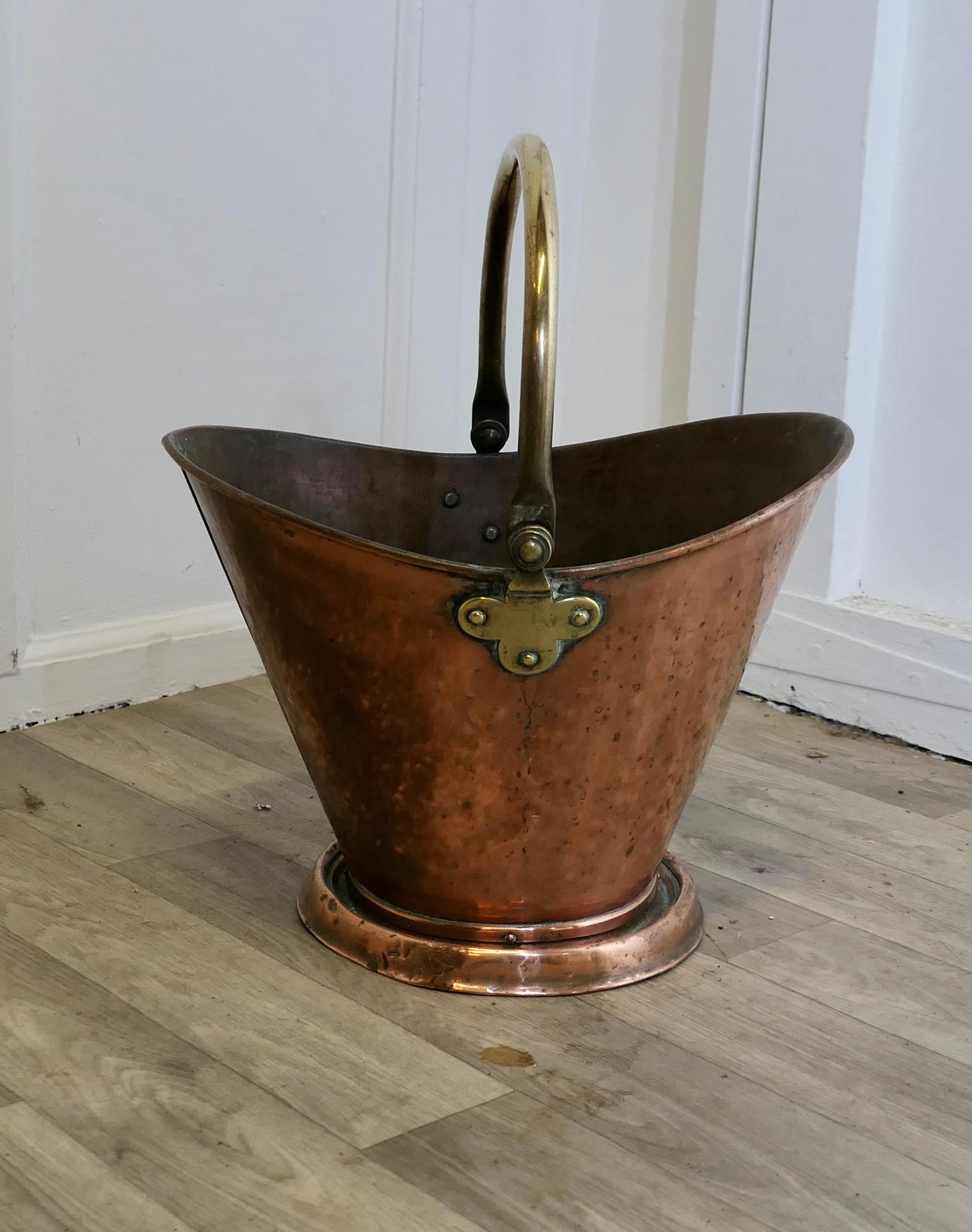Scuttle à charbon avec casque en cuivre (Arts and Crafts)  

Ce seau est d'une forme ovale très attrayante, il est fabriqué en cuivre battu avec une poignée pivotante en laiton.  
Le Condit est en très bon état d'usage et est prêt à travailler et à