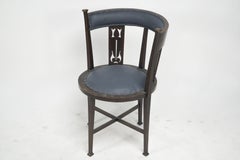 An Arts and Crafts mahogany tub chair with stylized floral cut outs