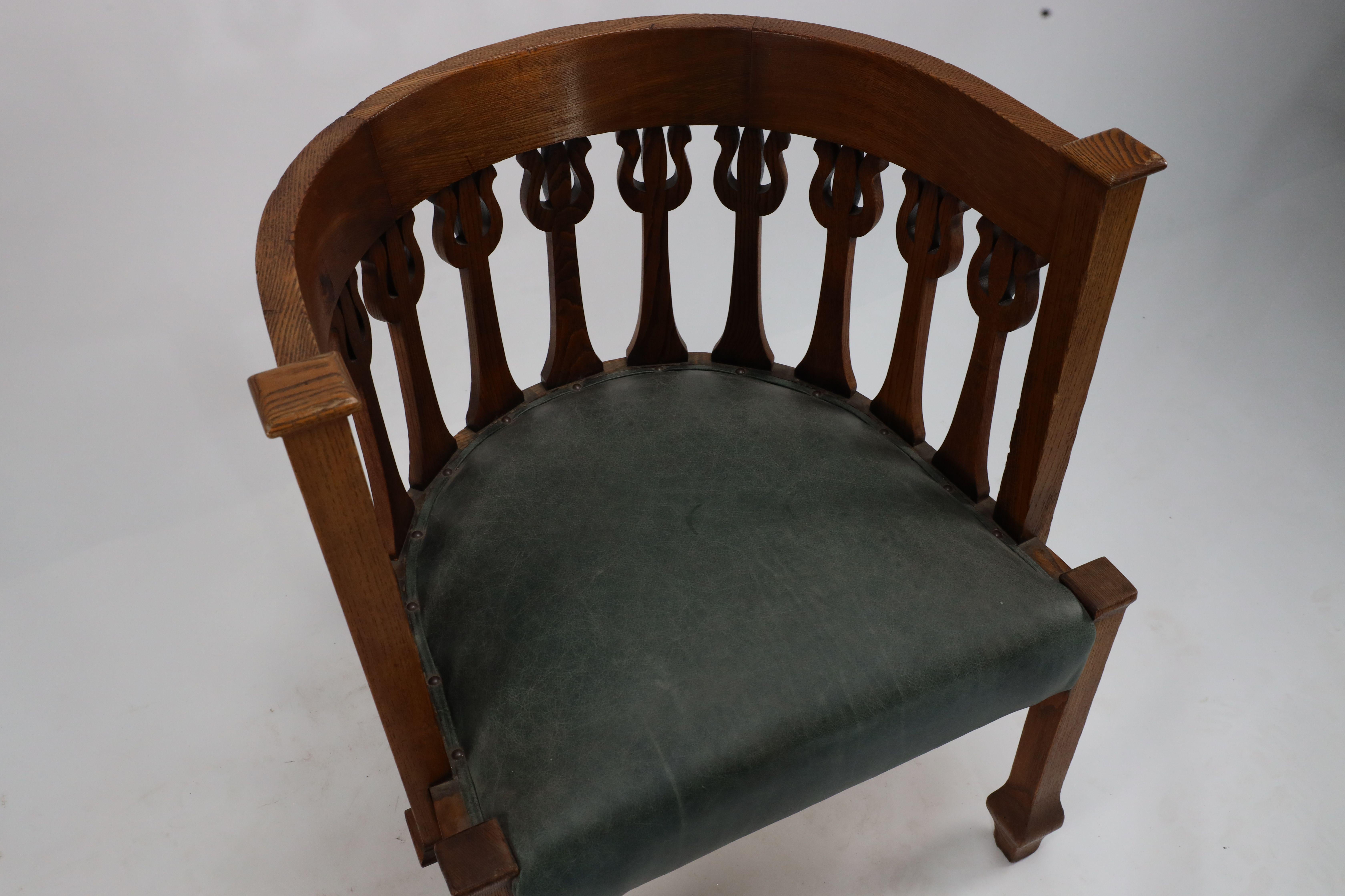 An Arts and Crafts oak armchair with stylized floral upright decoration For Sale 4