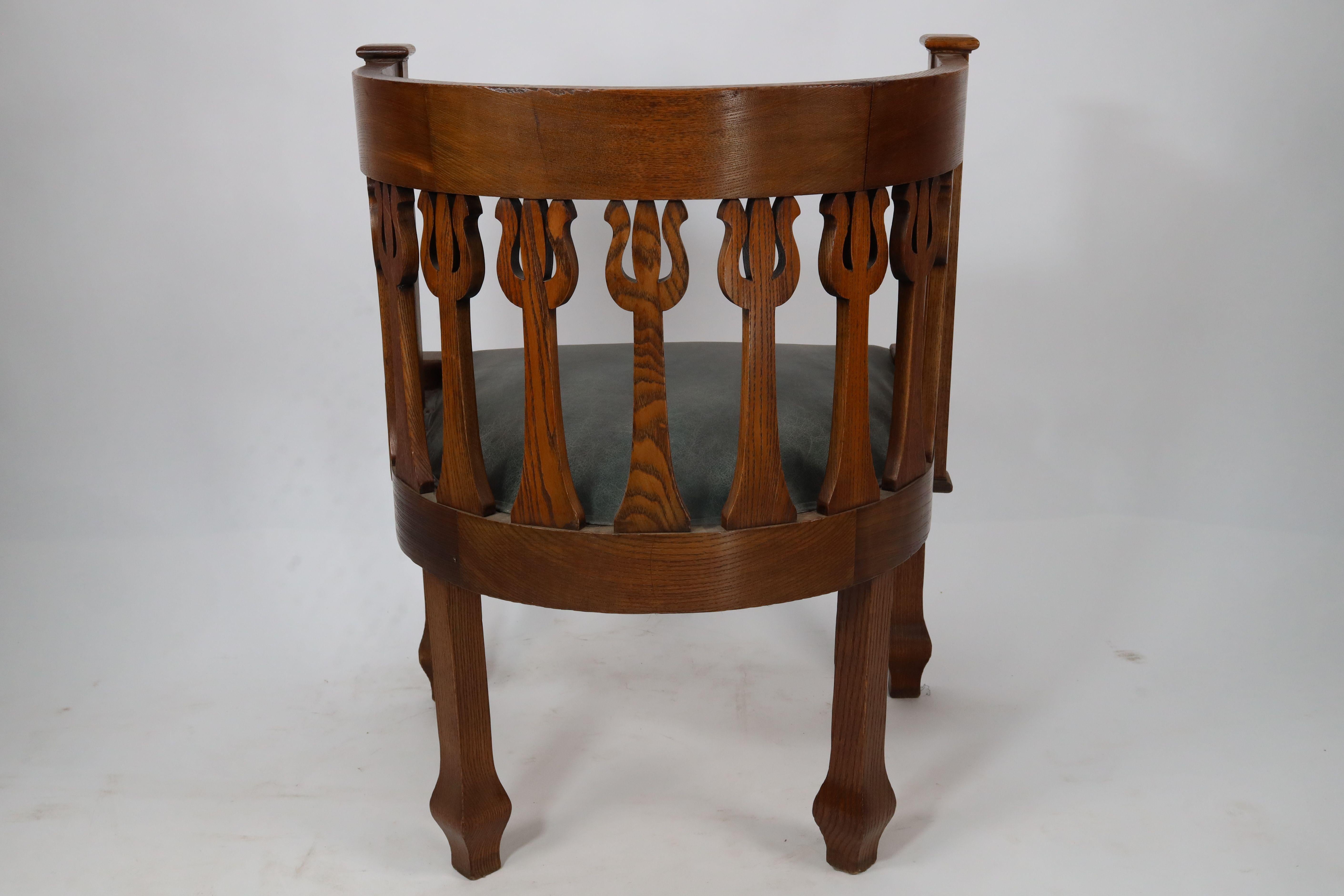 Early 20th Century An Arts and Crafts oak armchair with stylized floral upright decoration For Sale