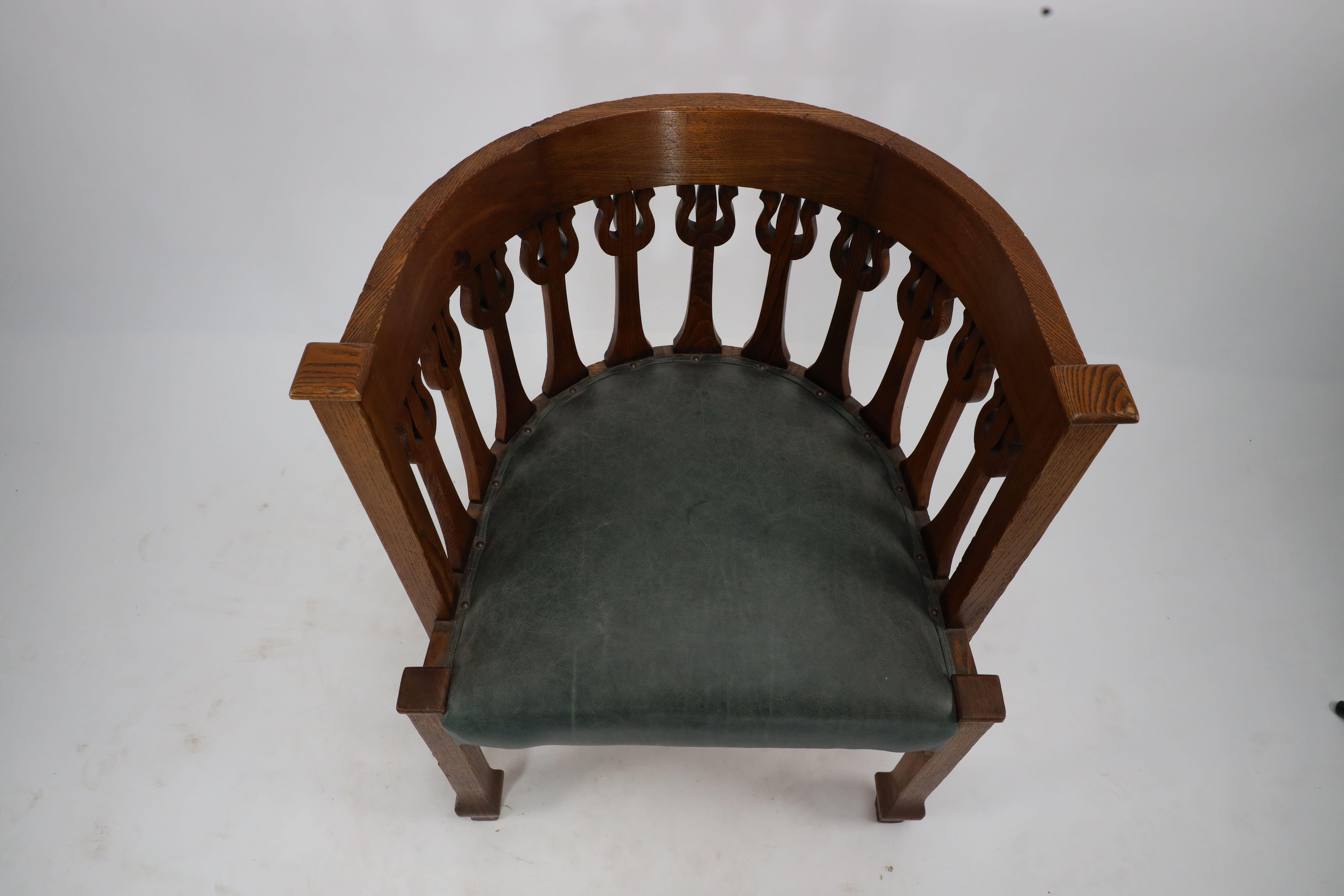 An Arts and Crafts oak armchair with stylized floral upright decoration For Sale 2