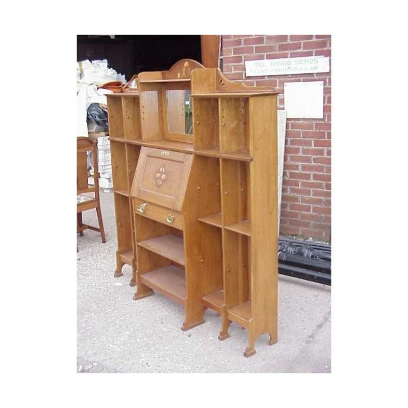 An Arts and Crafts oak bureau bookcase with beautiful stylised floral inlays and a very useful double bank of book storage to each side with an adjustable shelve to every space (shelves not shown). Height 65, Width 63 1/2, Depth 13