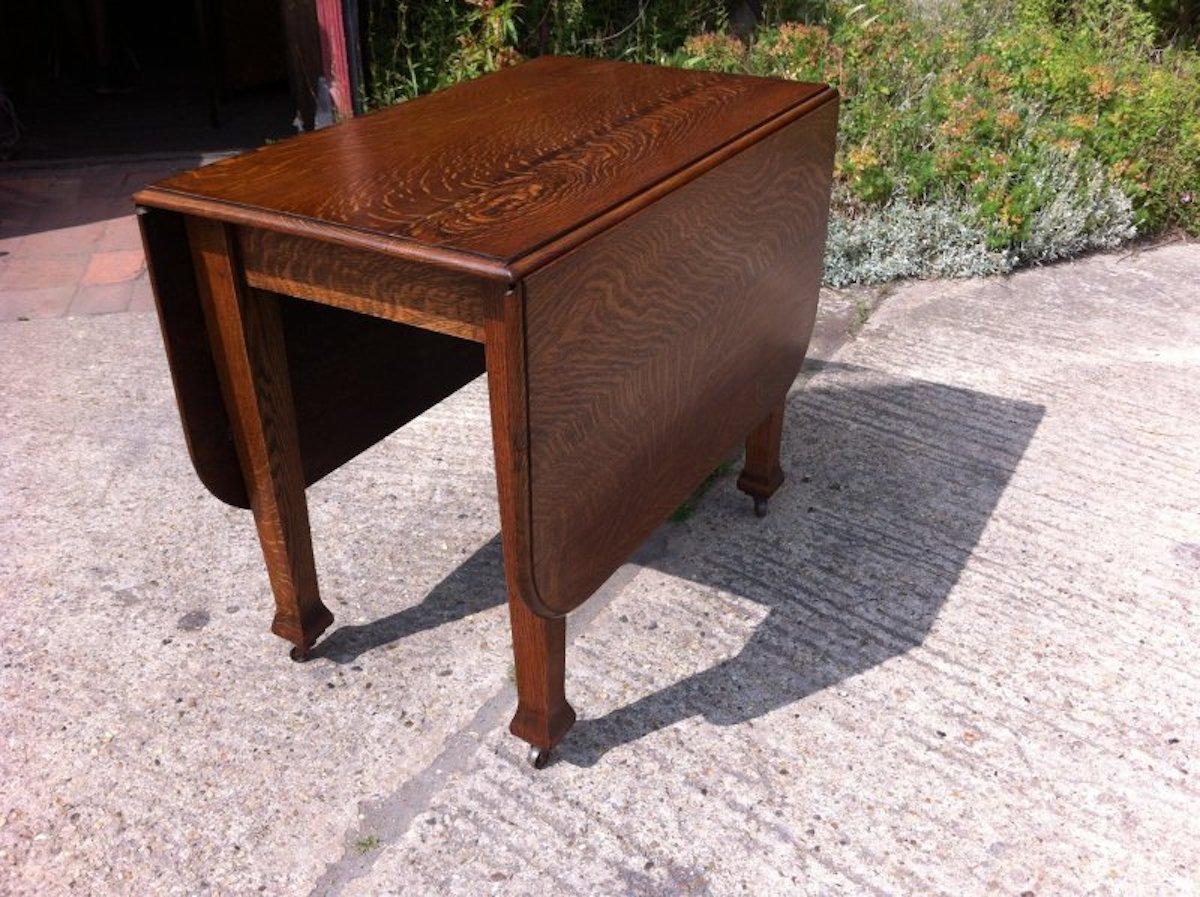 A good quality Arts & Crafts oak drop leaf/draw leg, extending dining table to seat six. 
The leaf is raised up and the legs slide out to support it making a very sturdy table indeed and you can have one leaf up at a time, a very neat