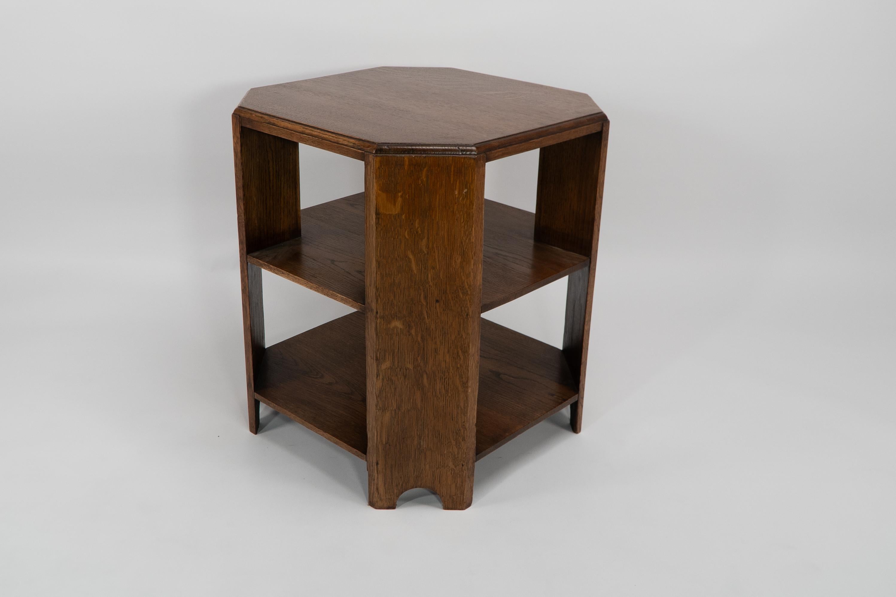 Heals. An Arts and Crafts oak octagonal book-reading coffee or side table with open compartments below to store books or papers.