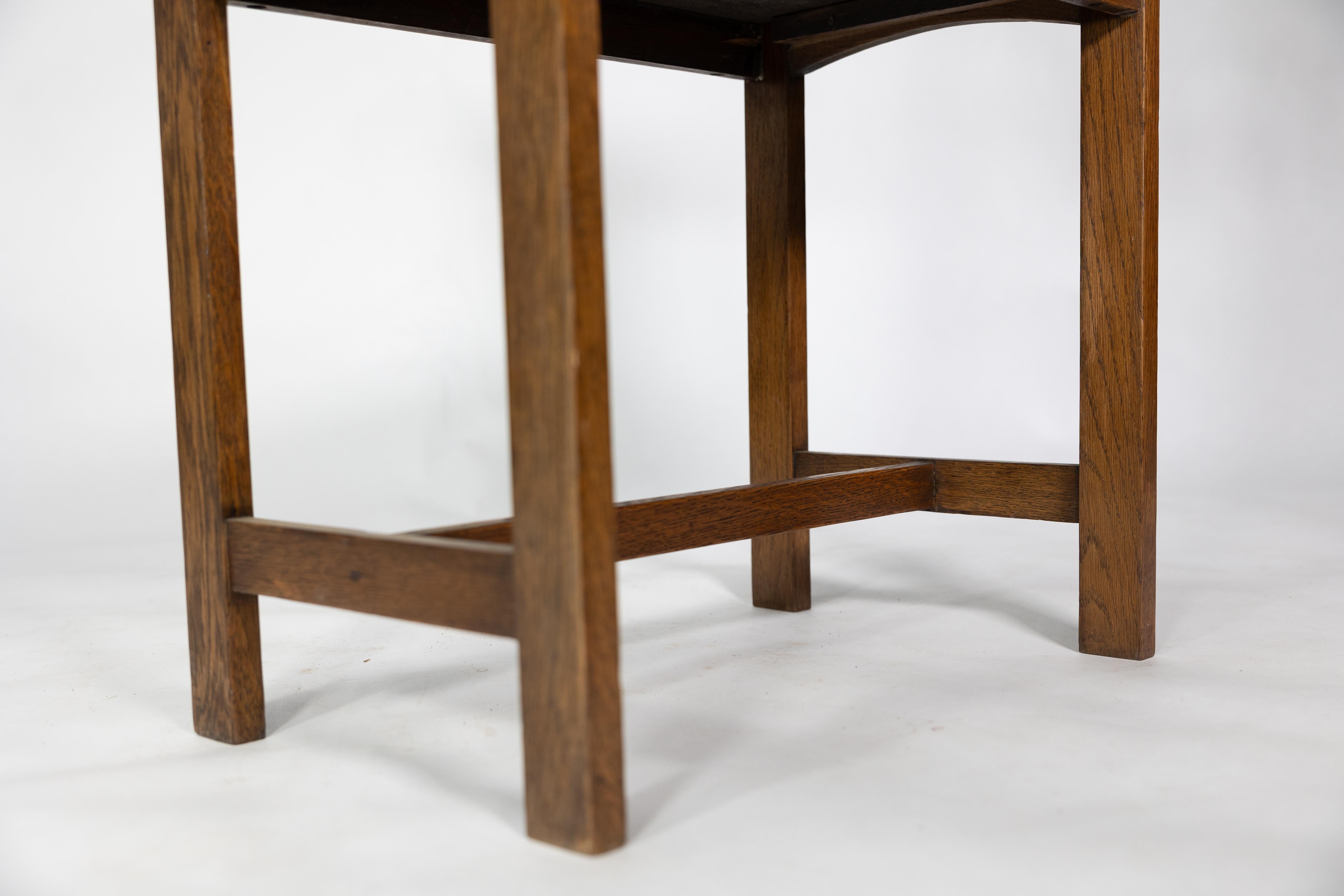 An Arts and Crafts oak piano stool with raised sides 11