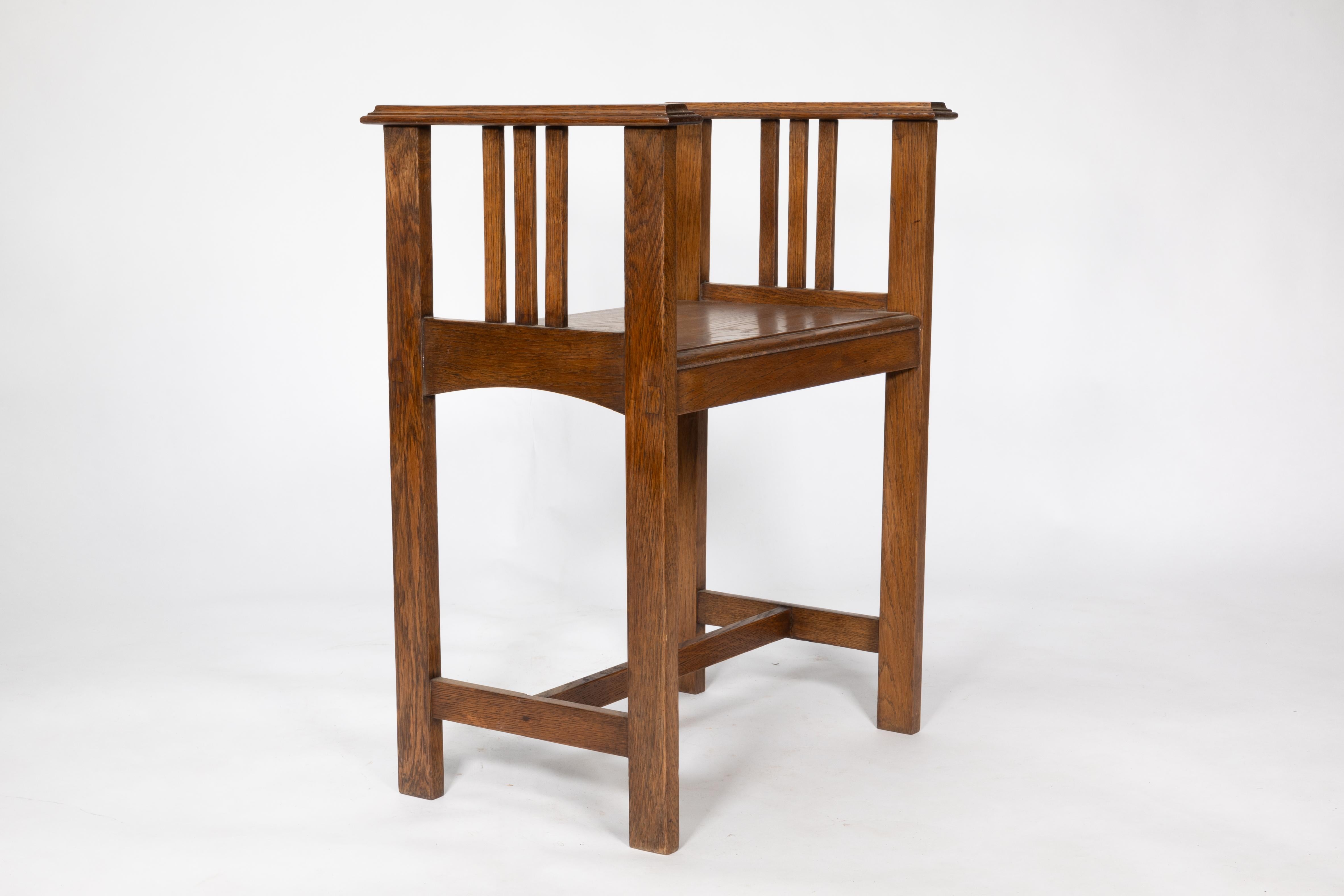 An Arts and Crafts oak piano stool with raised sides on straight legs united by an H stretcher.