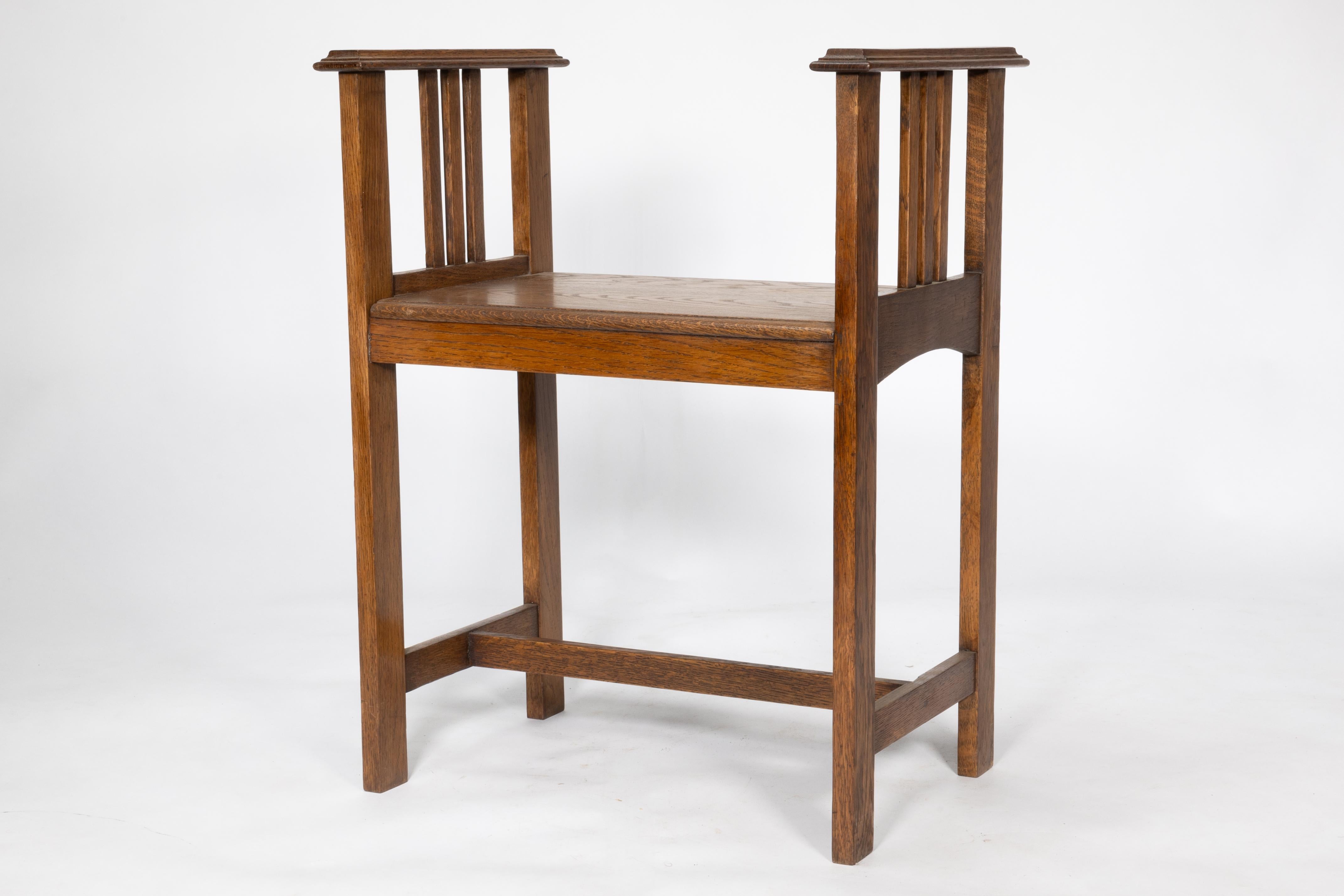 English An Arts and Crafts oak piano stool with raised sides