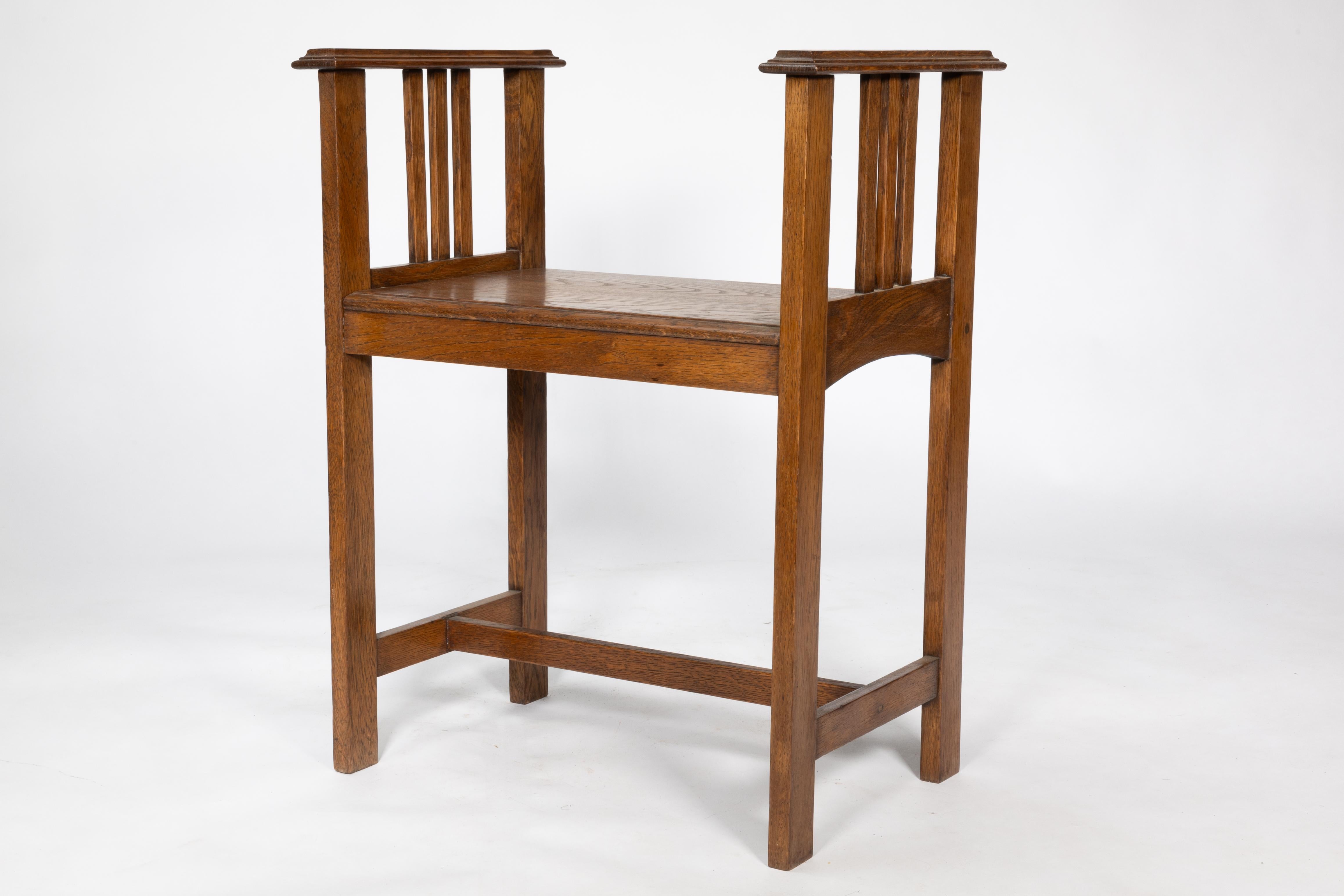 An Arts and Crafts oak piano stool with raised sides 1