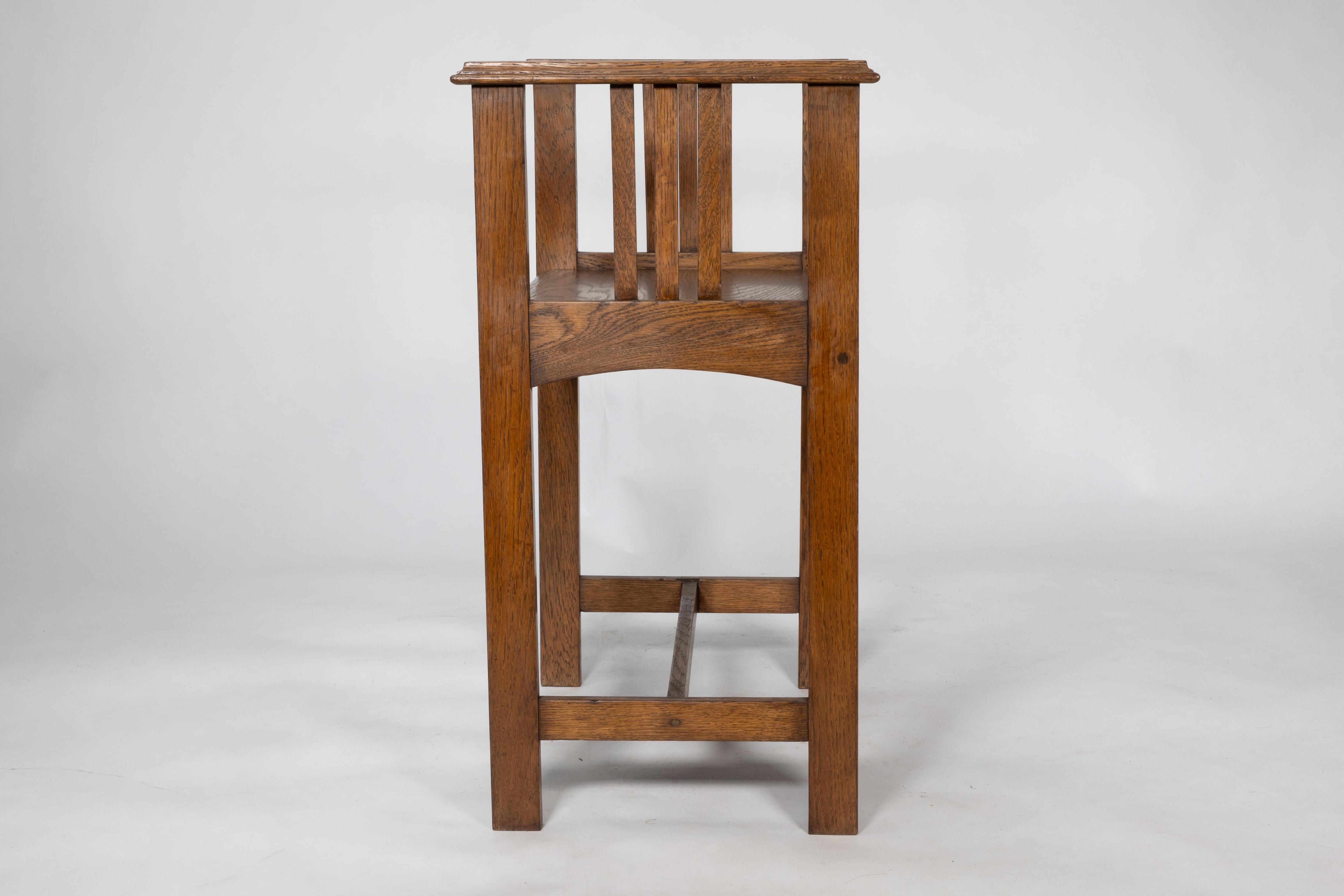 An Arts and Crafts oak piano stool with raised sides 2