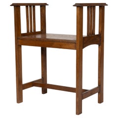 An Arts and Crafts oak piano stool with raised sides