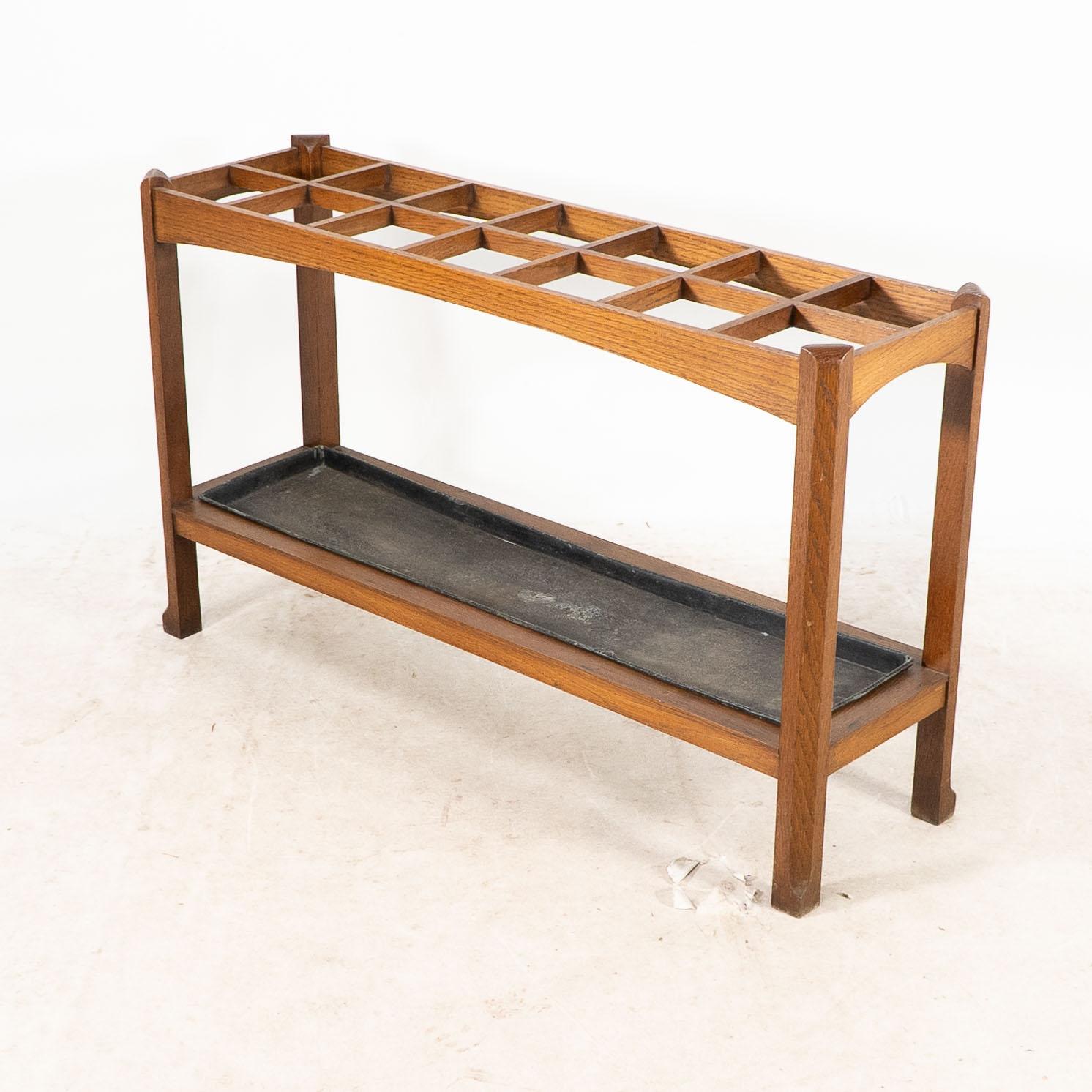 English An Arts and Crafts oak stick and umbrella stand with fourteen sections For Sale