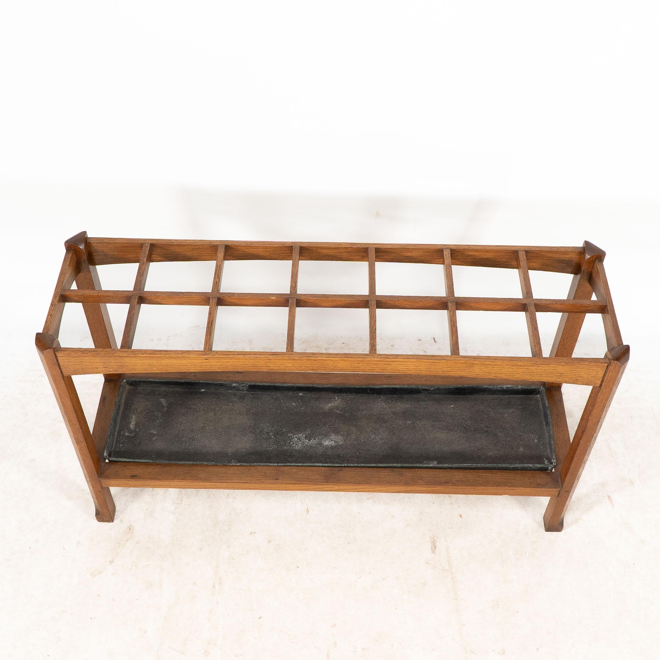 An Arts and Crafts oak stick and umbrella stand with fourteen sections For Sale 3