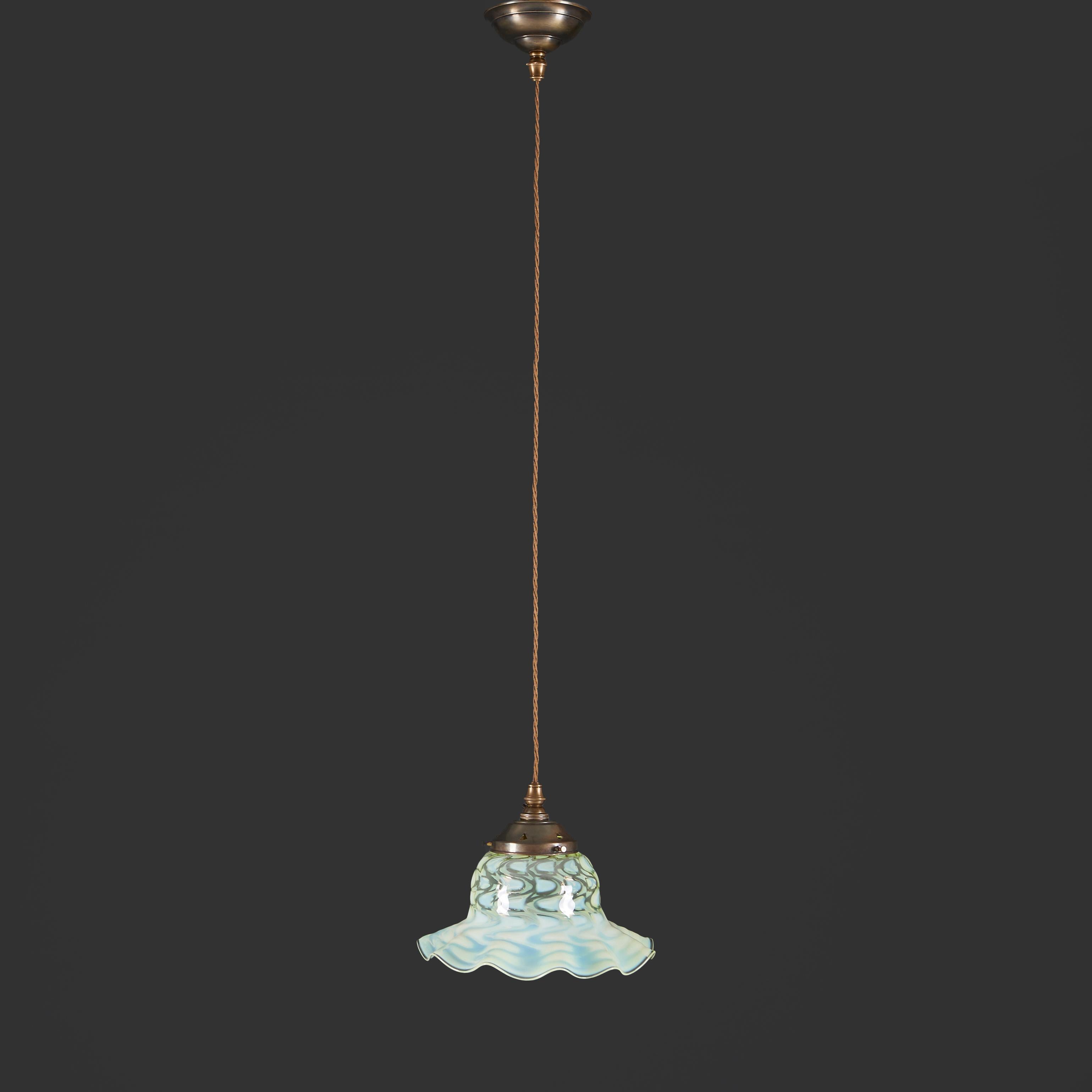 An early 20th century Arts and Crafts vaseline glass pendant light, the flared shade with undulating rim, supported by a patinated metal fixture with a matching ceiling rose.

Height of glass shade 20.00cm
Diameter 26.00cm
Drop adjustable

Please