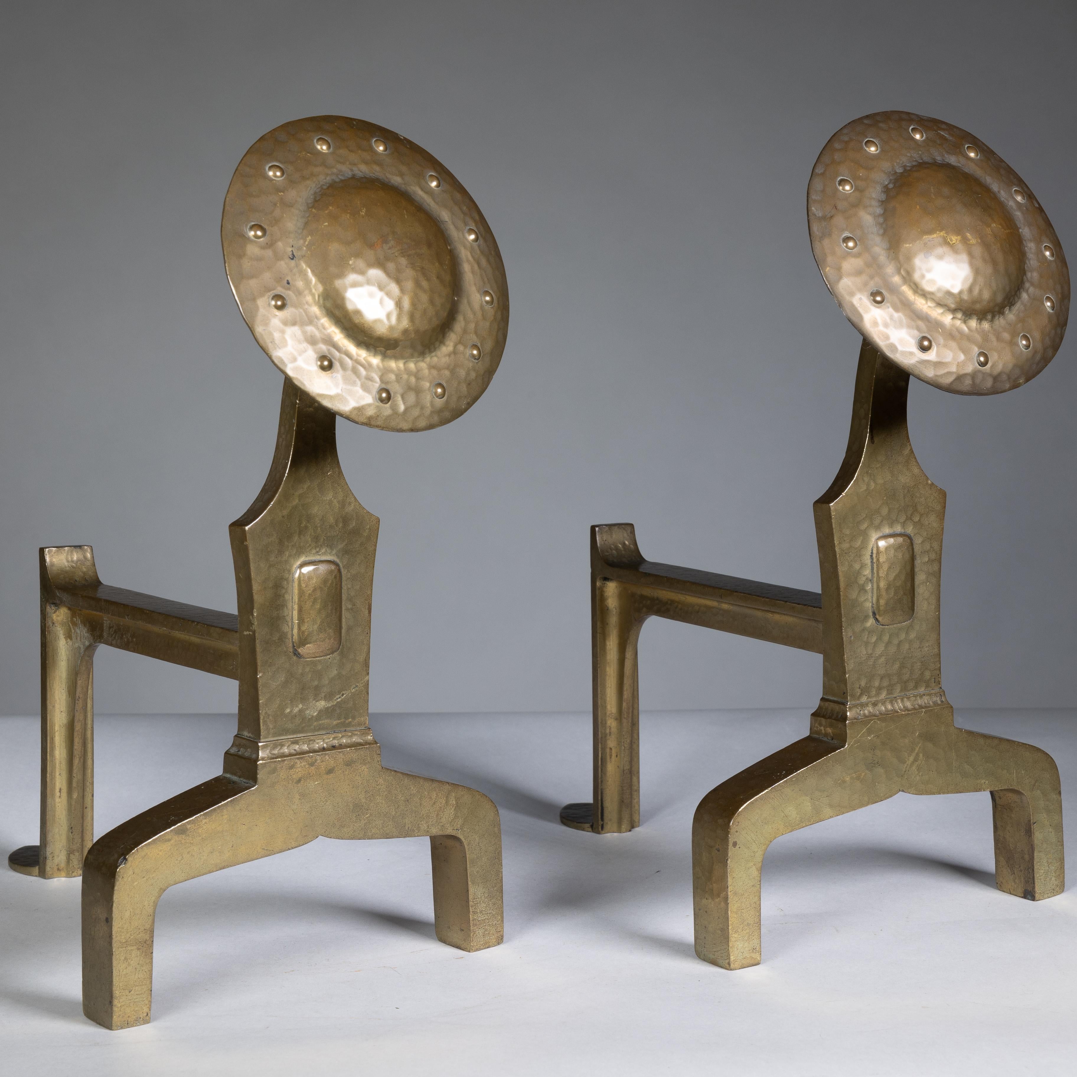 A fine quality Arts and Crafts set of brass fire dogs and matching utensils. 
Measures: Fire dogs height 12