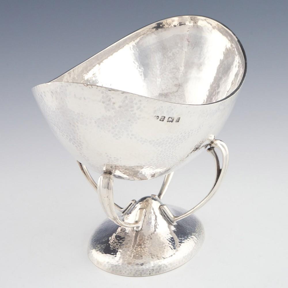 A 1906 Arts and crafts sterling sliver hammered boat shaped bowl with pedestal foot. Originated in Birmingham, England and hallmarked for Williams Limited.