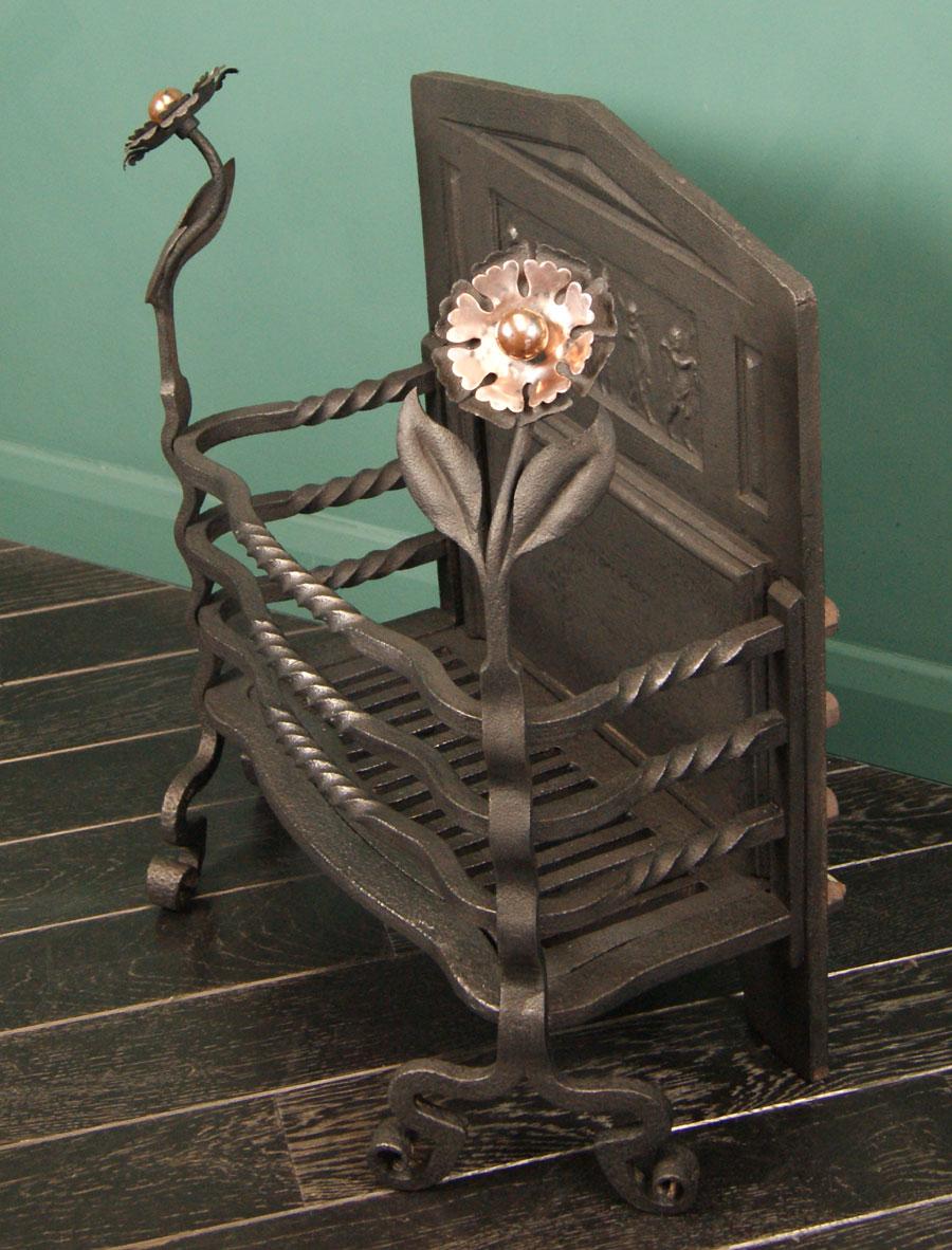 Un brasero en fer forgé de style Arts & Crafts avec une torsion centrale aux barres de feu, des fleurons en bronze et un panneau central orné au dos de la cheminée en fonte façonnée.
Restauré.
Circa 1880