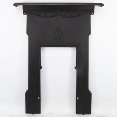 An Arts & Crafts / Art Nouveau cast iron fireplace with stylized floral details