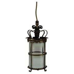 An Arts & Crafts brass ceiling lantern with the original vaseline shade