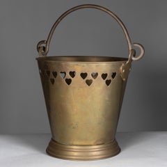 An Arts & Crafts brass champagne bucket with pierced Voysey style heart decor