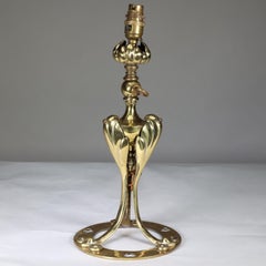 An Arts & Crafts brass table lamp tulip shaped with heart cut-outs to the base