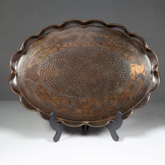 An Arts & Crafts copper tray with floral decoration and folded wavy edges
