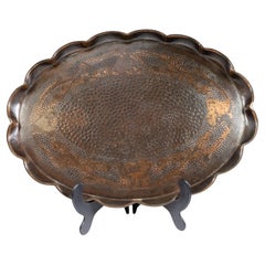 An Arts & Crafts copper tray with floral decoration and folded wavy edges