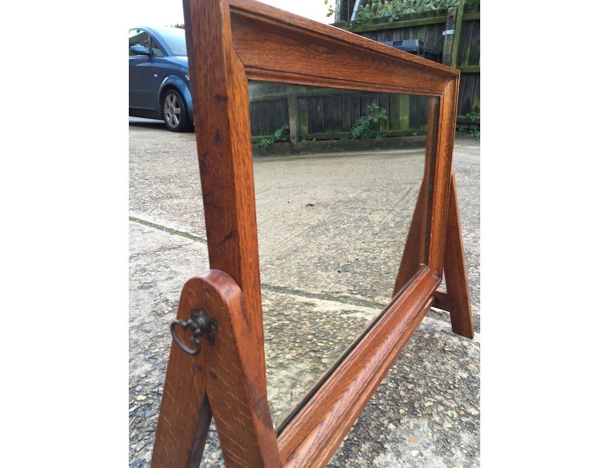 In the style of Gordon Russell. A good quality Arts & Crafts Cotswold School oak dressing table swivel mirror, with A-frame sides, united by a lower wide stretcher with through tenon pegs and further dowelled joints through making it a very strong