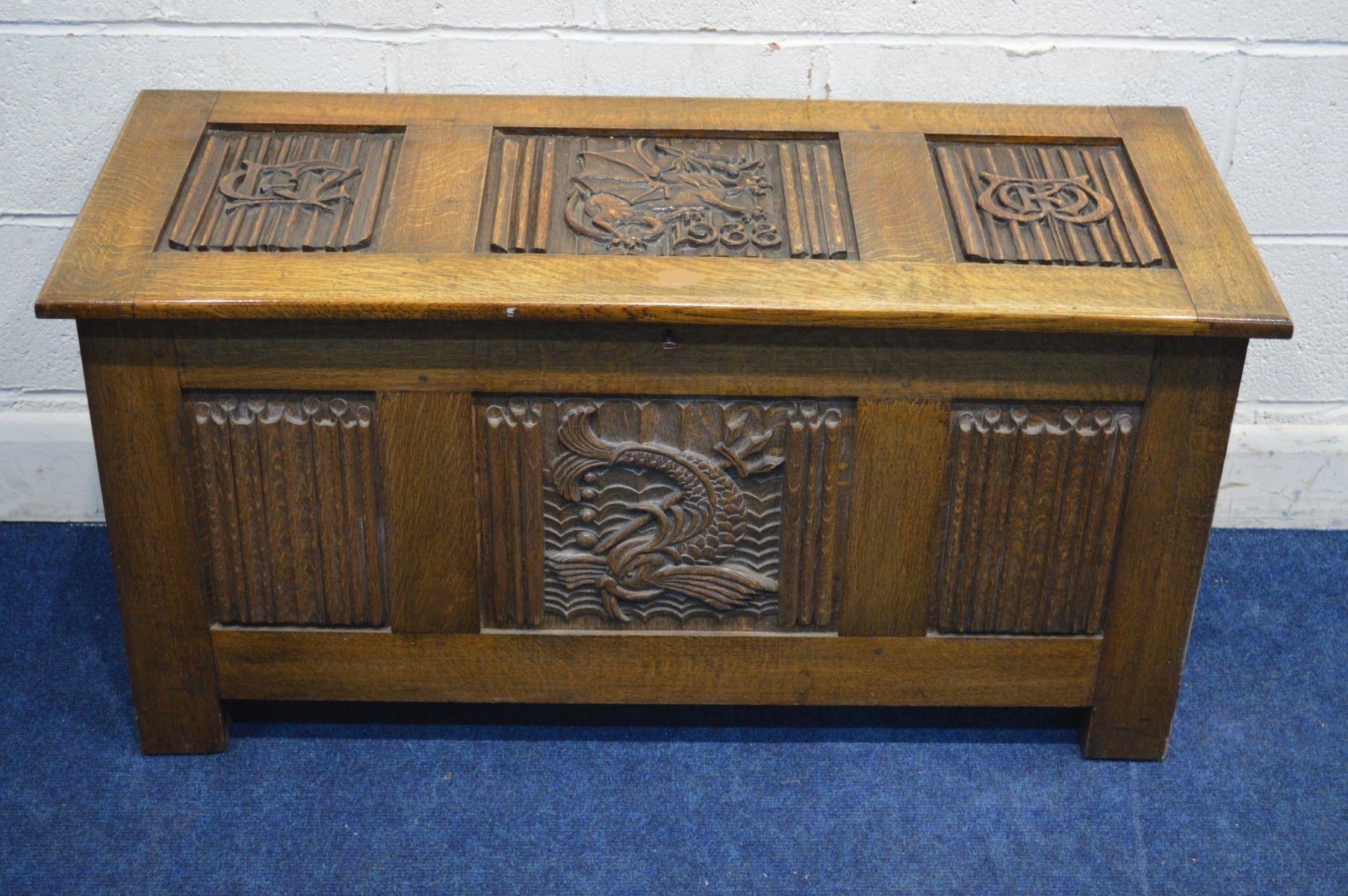 An English Arts & Crafts oak blanket chest, with a beautifully carved dragon to the top and dated 1938, flanked by two carved initials set in linenfold carvings. The initial on the left is possibly GCL, and to the right possibly MKM but any